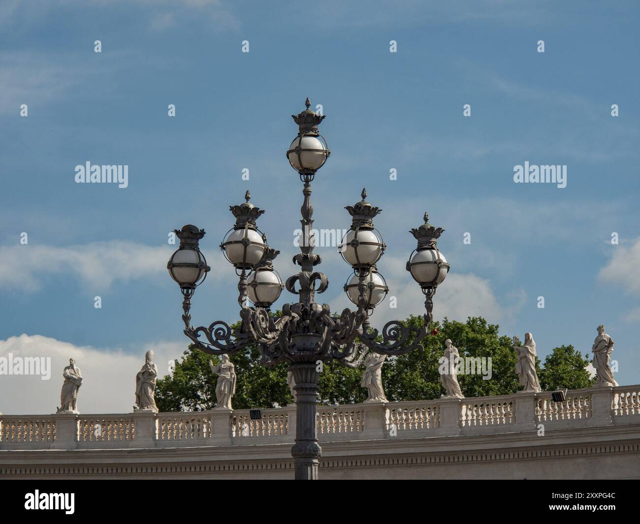 Antike Straßenlaterne vor einer Reihe von Statuen und einem blauen Himmel, rom, italien Stockfoto