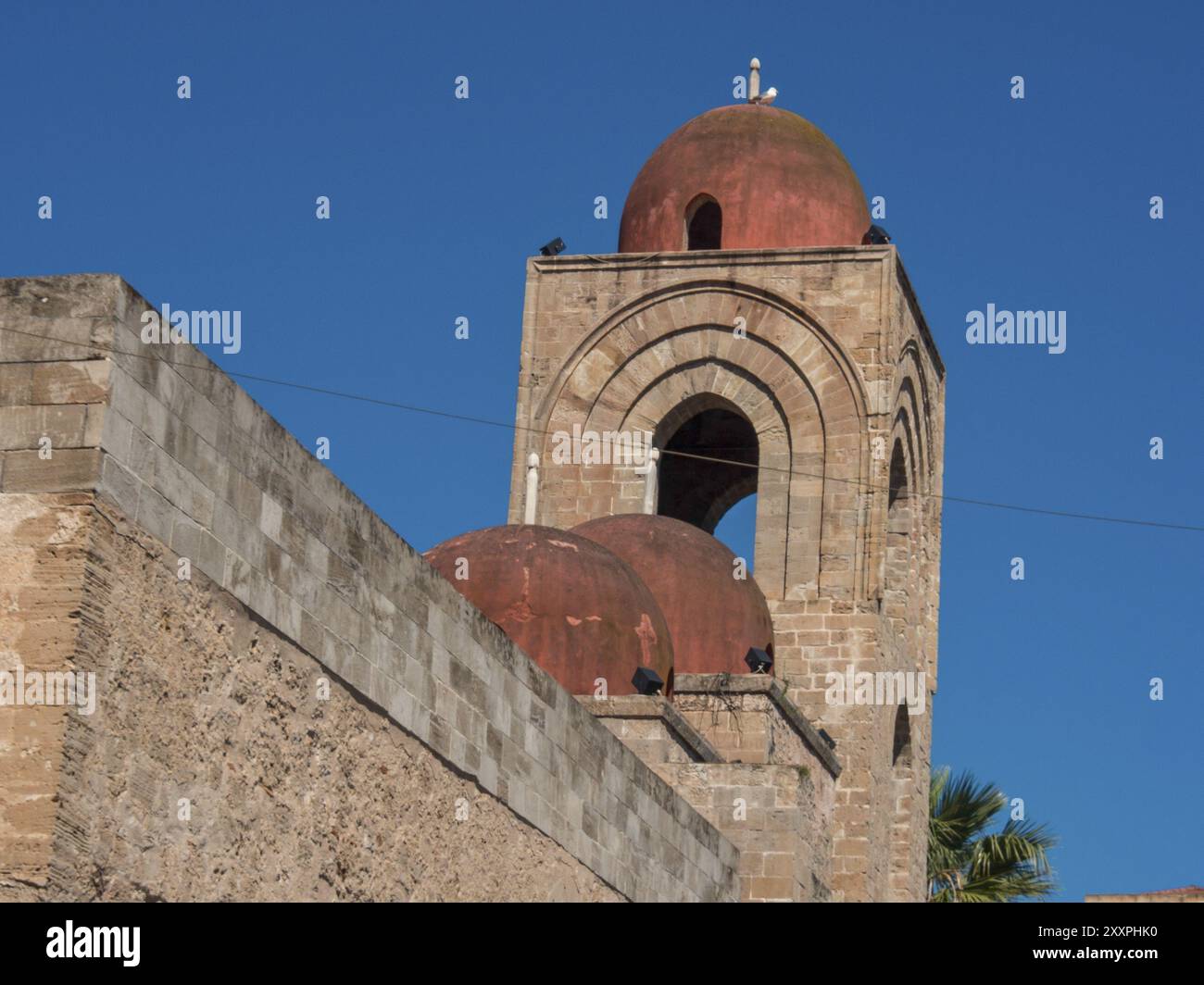 Ein alter Kirchturm mit roten Kuppeln und Steinmauern unter blauem Himmel, palermo, sizilien, mittelmeer, italien Stockfoto