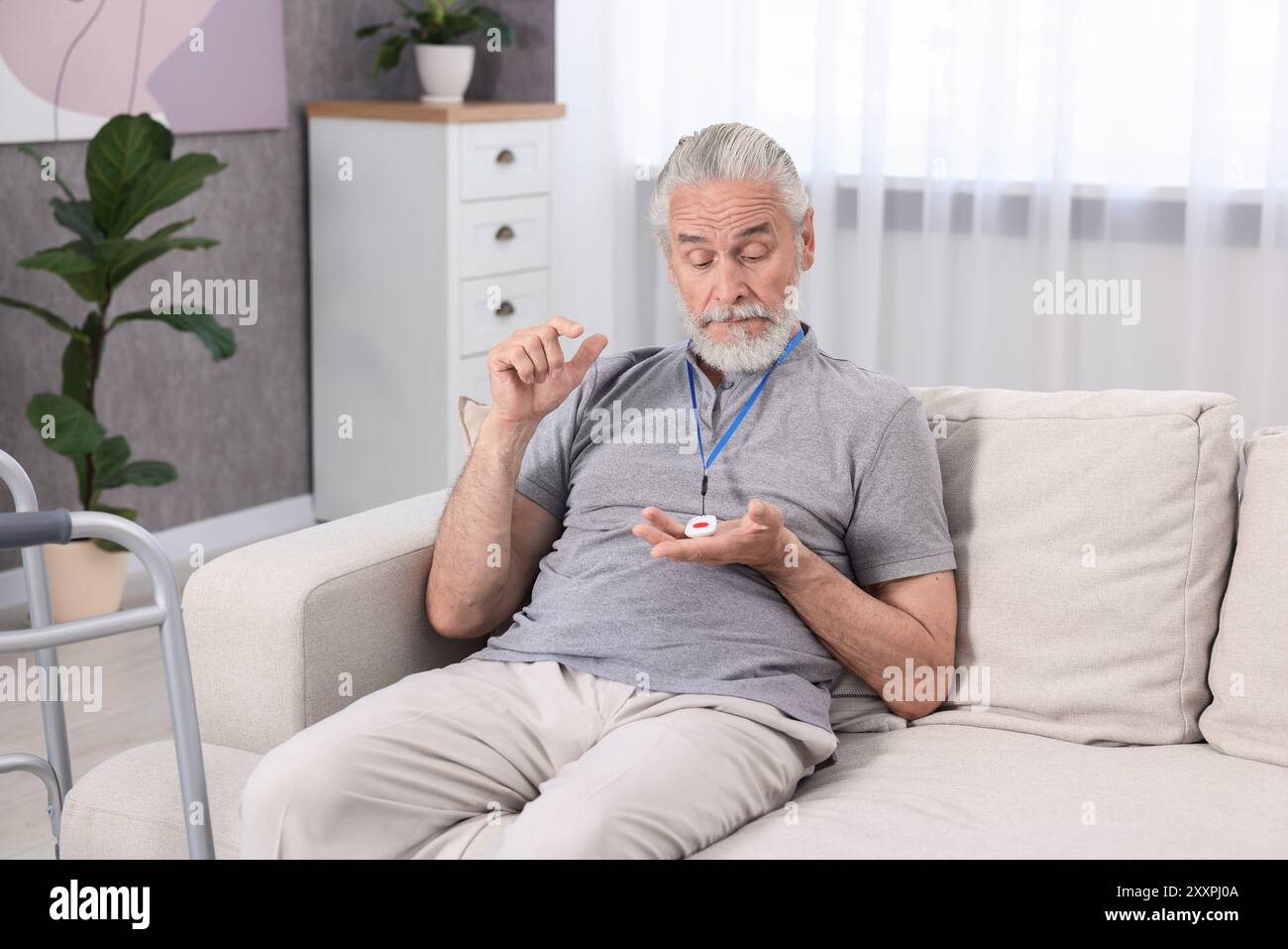 Senior Mann mit Notruftaste zu Hause Stockfoto