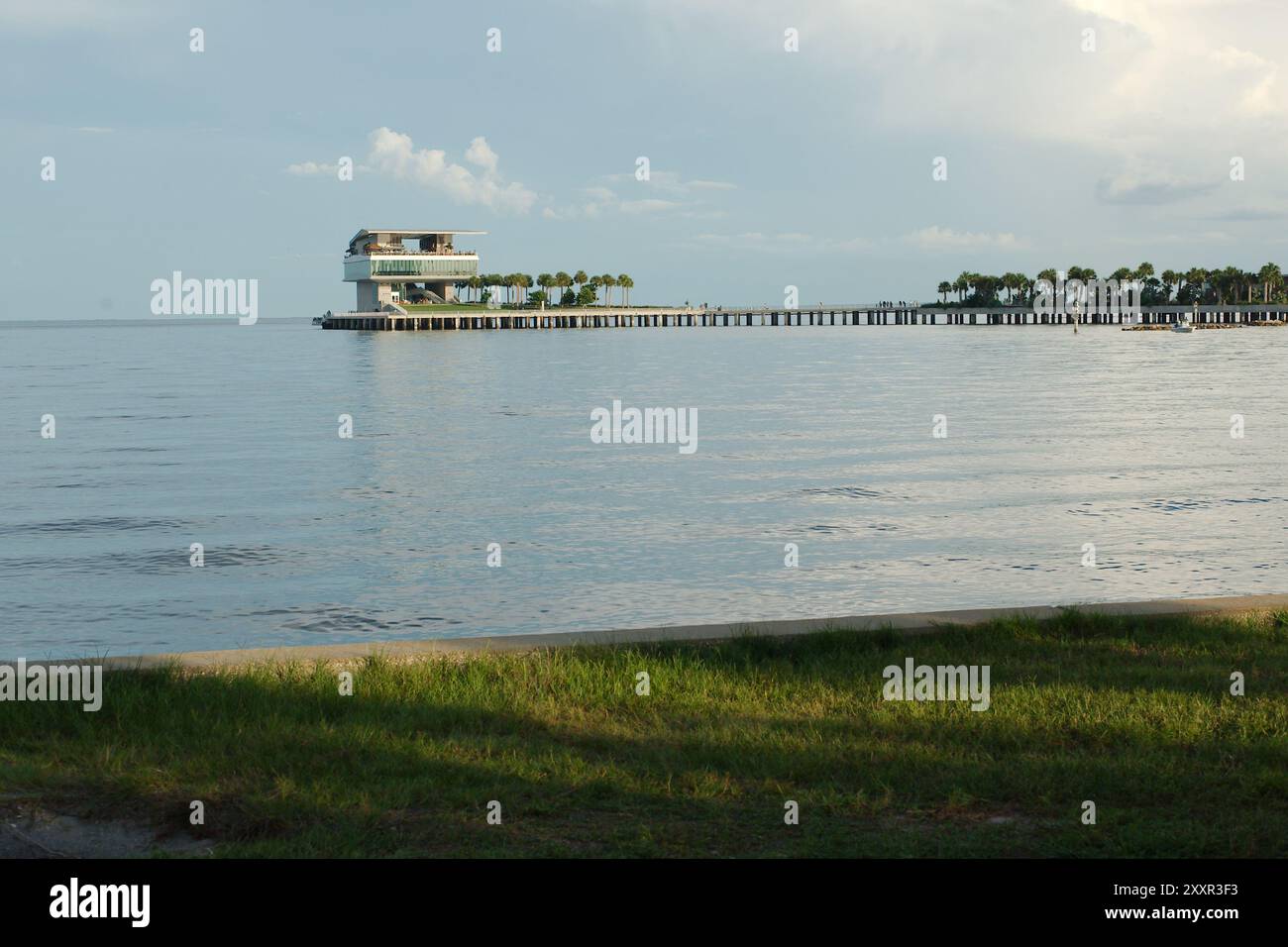 Mittelgroßer Blick nach Süden über ruhiges blaues Wasser vom Strand St. Petersburg, FL. Richtung Tampa Bay und Pier hinten. Teilweise sonniger Tag mit blauem Himmel Stockfoto