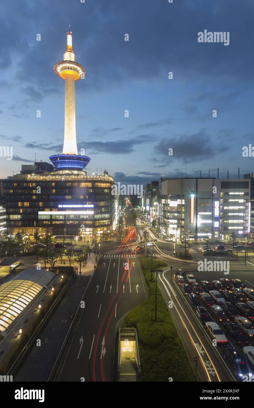 Wunderschön beleuchteter Kyoto Tower, Stadtgebäude und Straßenlaternen in der Innenstadt, die in der Abenddämmerung während der blauen Stunde in der Geschichte zu sehen sind Stockfoto