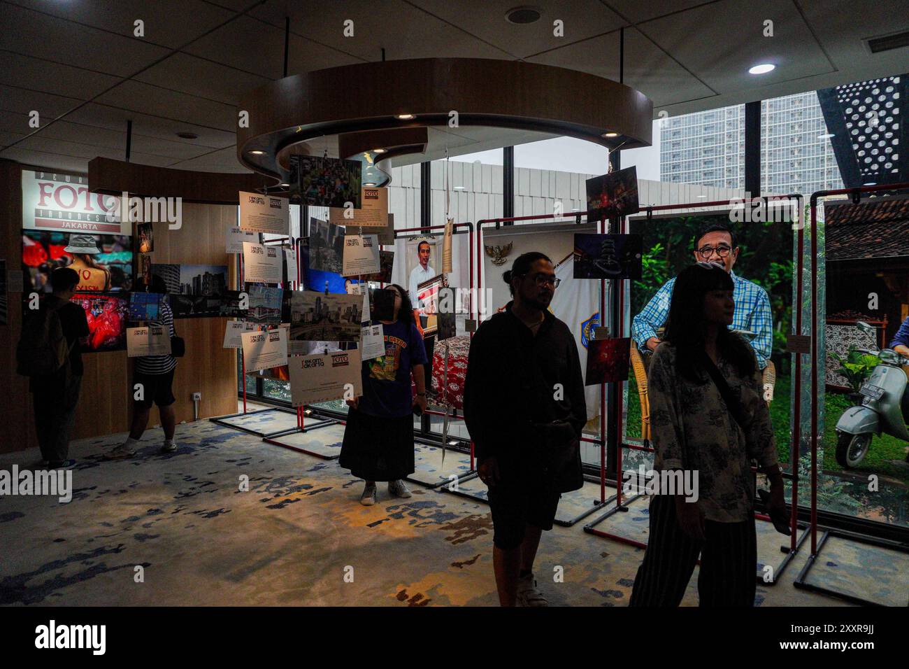 Indonesien. August 2024. Besucher sehen die Fotos, die am Samstag (24.8.2024) in der Jakarta Record Fotoausstellung in der Jakarta Library der HB Jassin PDS Gallery, Taman Ismail Marzuki, Jakarta, Indonesien, ausgestellt wurden. Pewarta Foto Indonesia (PFI) Jakarta hält erneut eine journalistische Fotoausstellung mit dem Thema Rekam Jakarta 2024: Sayonara Jakarta. Diese Ausstellung findet vom 23. Bis 31. August 2024 statt und zeigt 96 Einzelfotos und 10 Geschichtenfotos aus der Zeitspanne der Ereignisse von 2023 bis 2024. (Kreditbild: © Andri Munazir/ZUMA Press Wire) NUR REDAKTIONELLE VERWENDUNG! Nicht für kommerzielle Zwecke Stockfoto