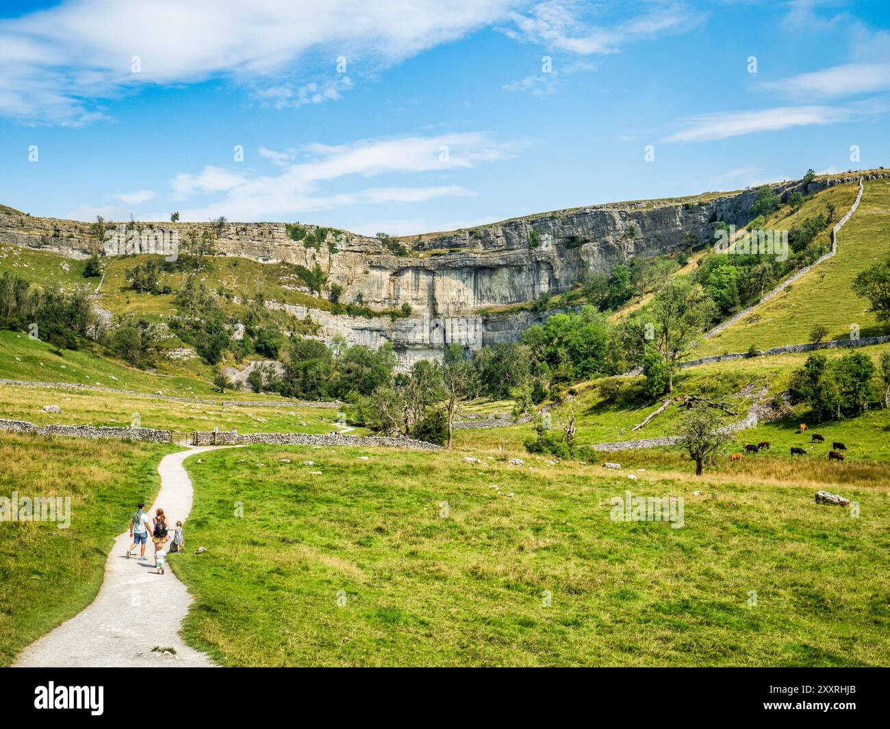 2. August 2024: Malham Cove, North Yorkshire, Vereinigtes Königreich - Eine Familie, die auf dem Fußweg in Richtung Malham Cove im Yorkshire Dales National Park spaziert Stockfoto