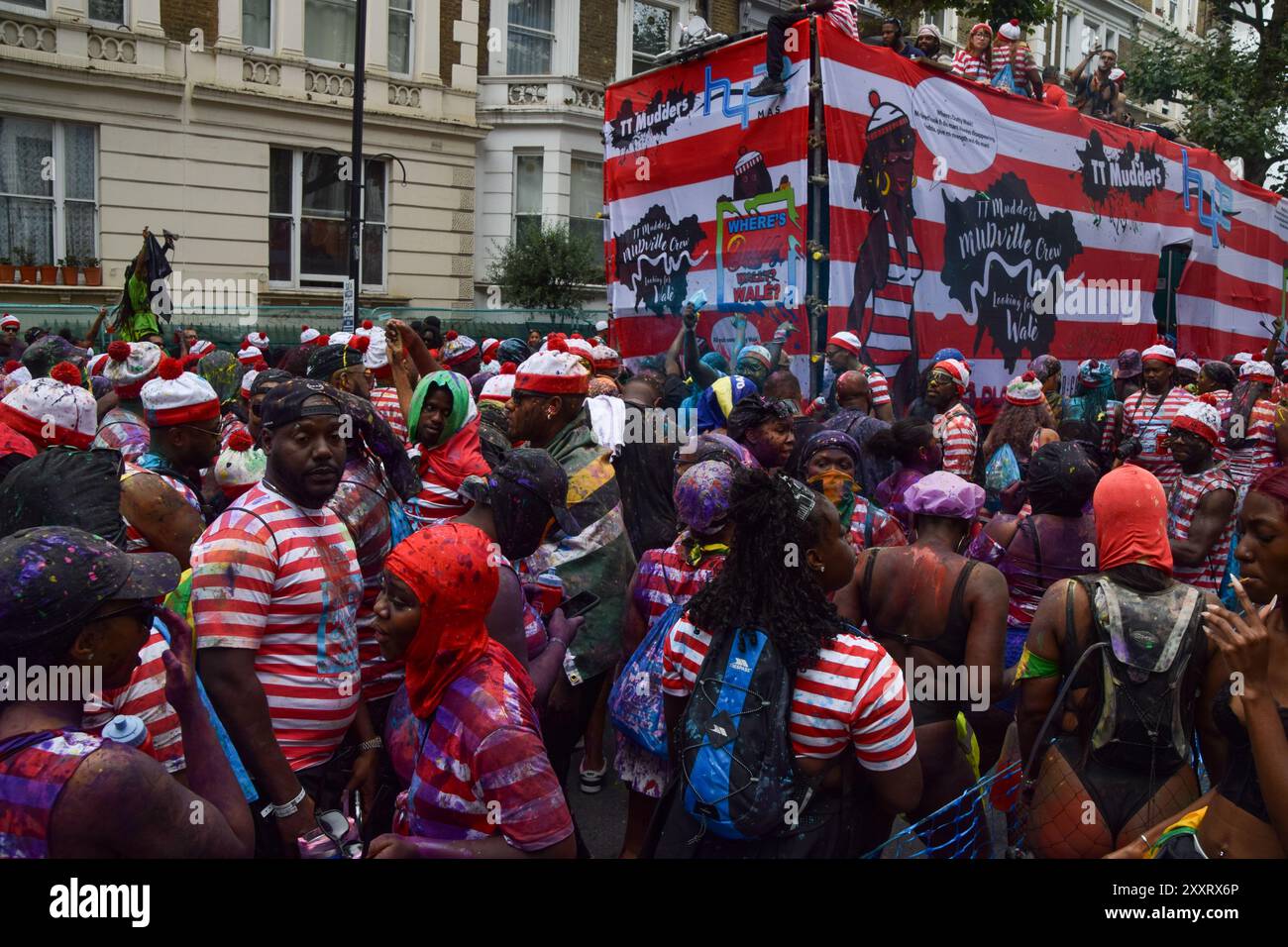 London, Großbritannien. August 2024. Als Puzzlebucherfigur verkleidet, sprühen Wally am ersten Tag des Notting Hill Carnivals bunte Farbe und Pulver auf sich und die Zuschauer. Quelle: Vuk Valcic/Alamy Live News Stockfoto