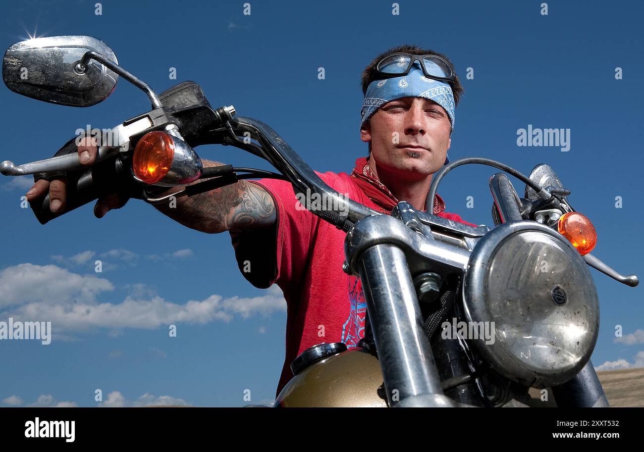 Motorrad-Biker-Typ mit Tattoos und harter Männereinstellung Stockfoto