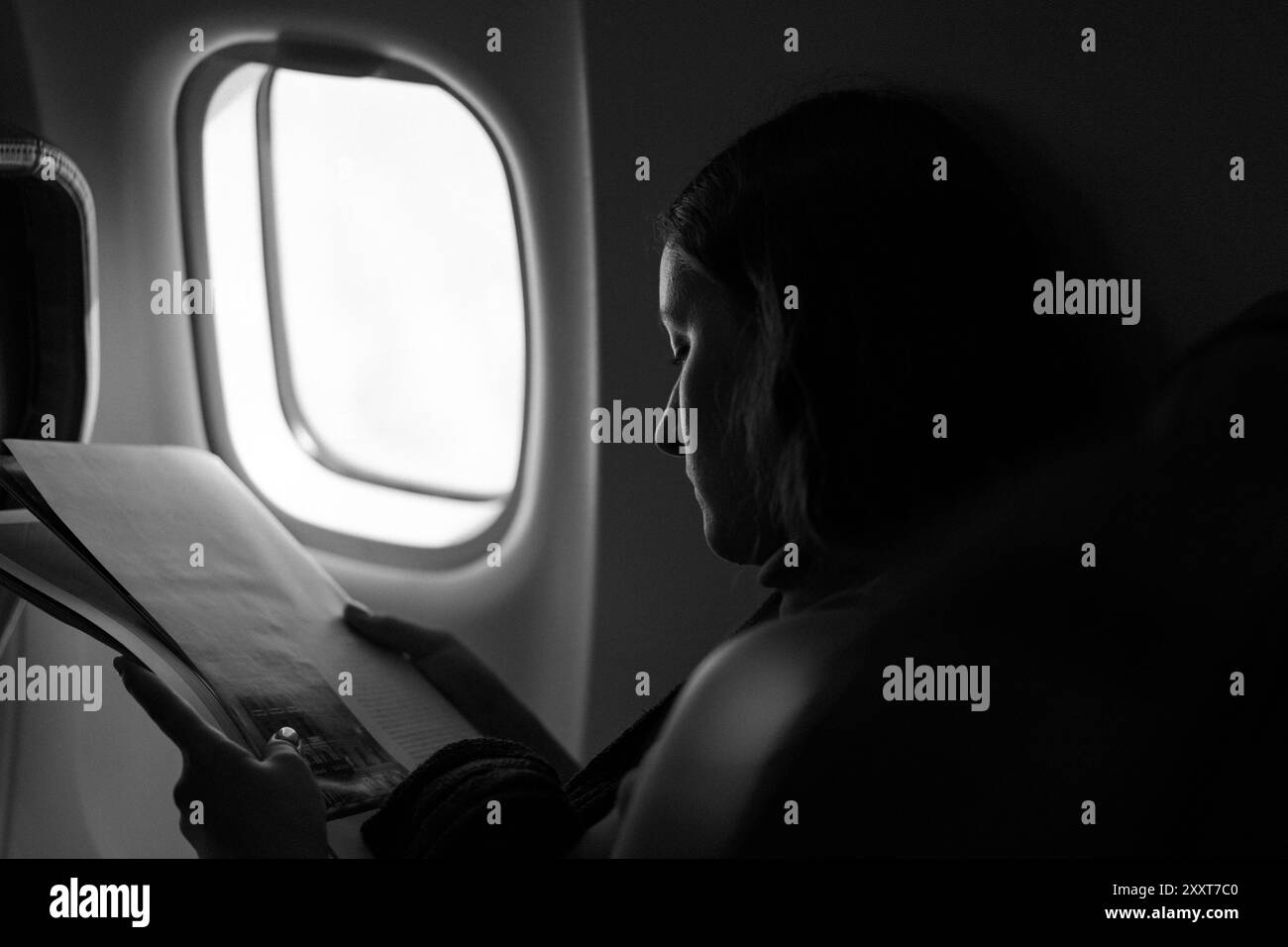 Frau liest Magazin auf Flugzeugflug. Stockfoto