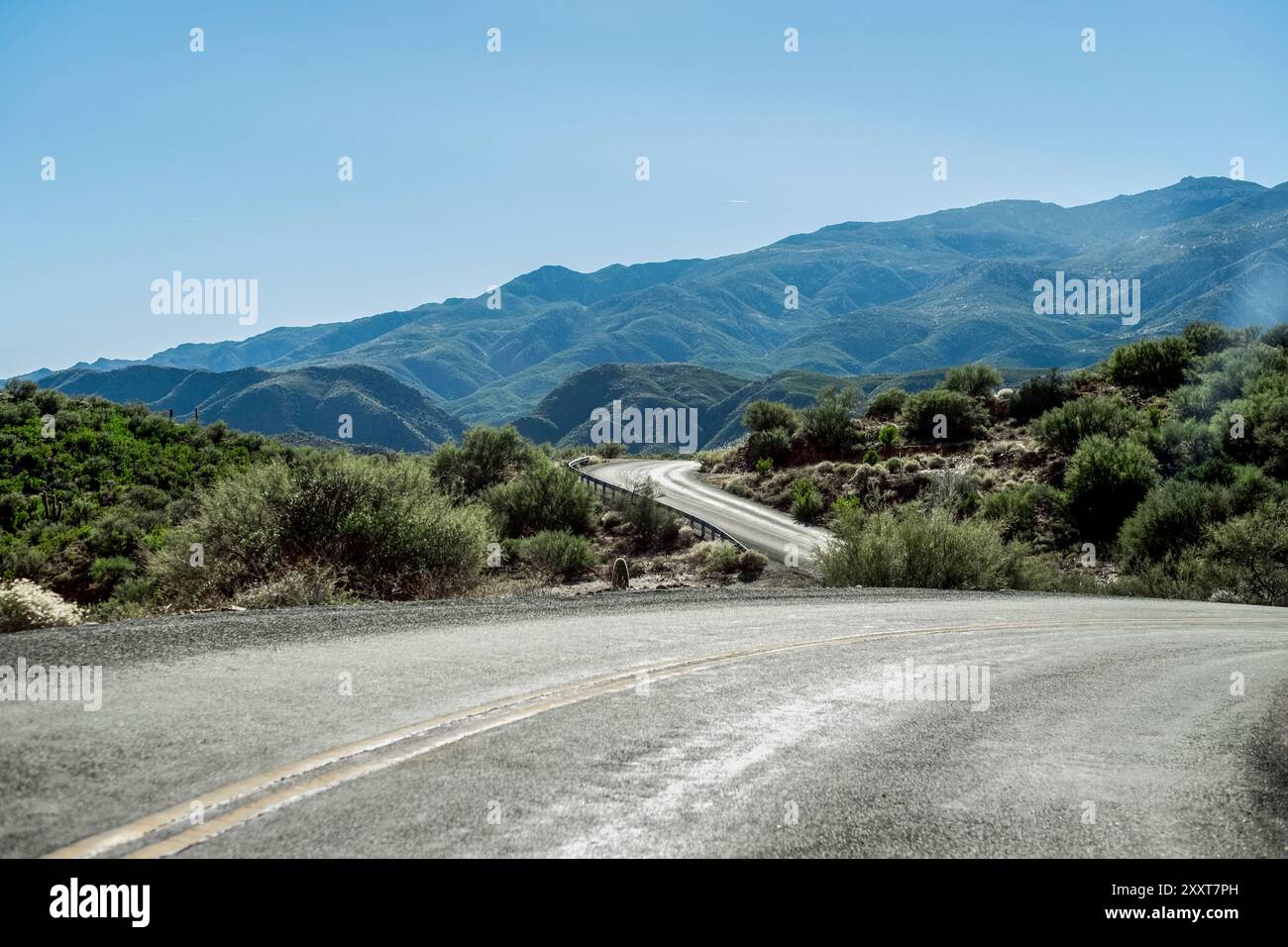 Eine gewundene Straße in üppiger bergiger Umgebung Stockfoto