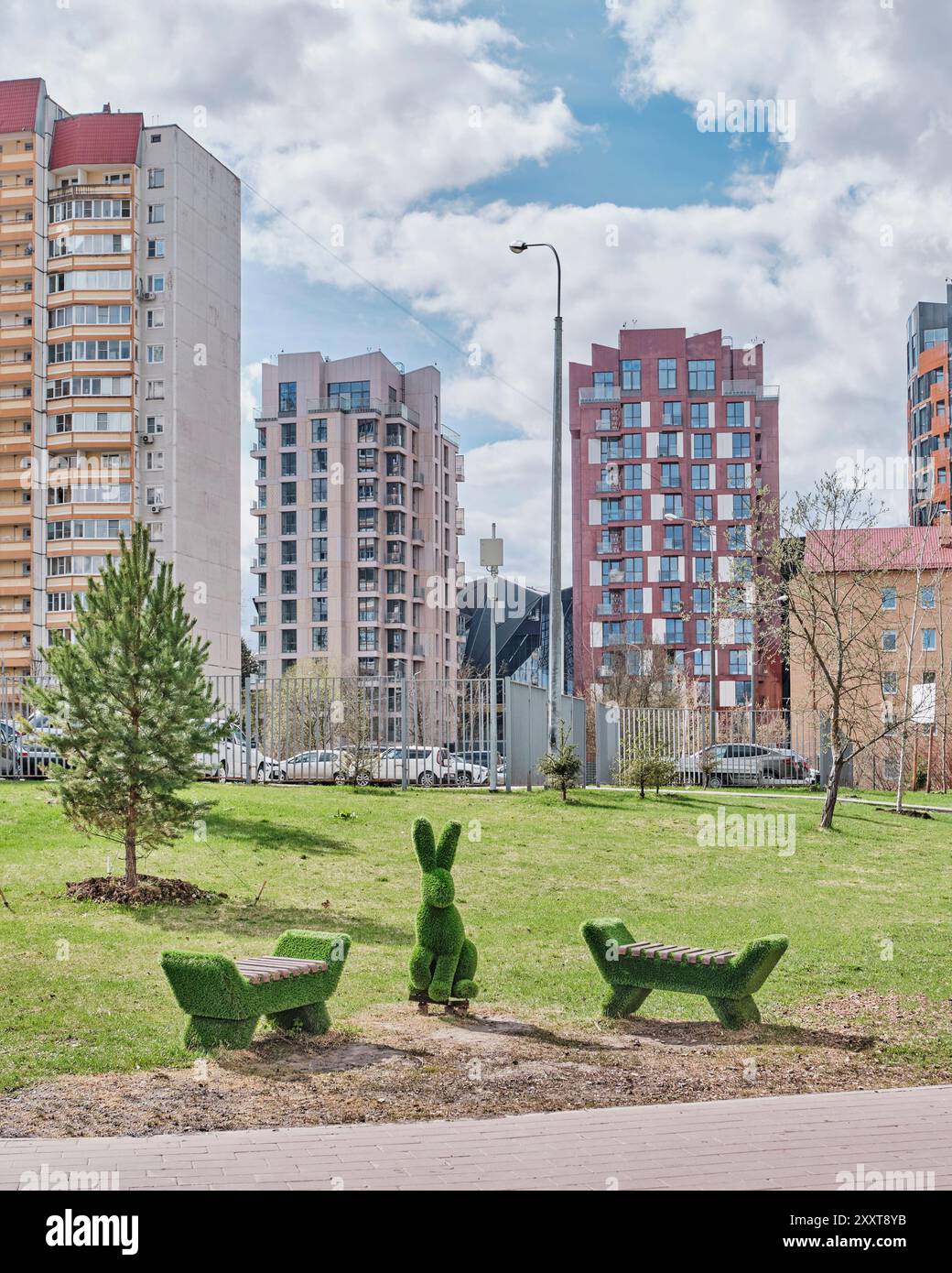 Moskau, Russland - 16. April 2024: Komposition, kleine architektonische Formen, Figur eines Hasen oder Kaninchens und zwei Bänke aus Kunstrasen, Topiar, i Stockfoto