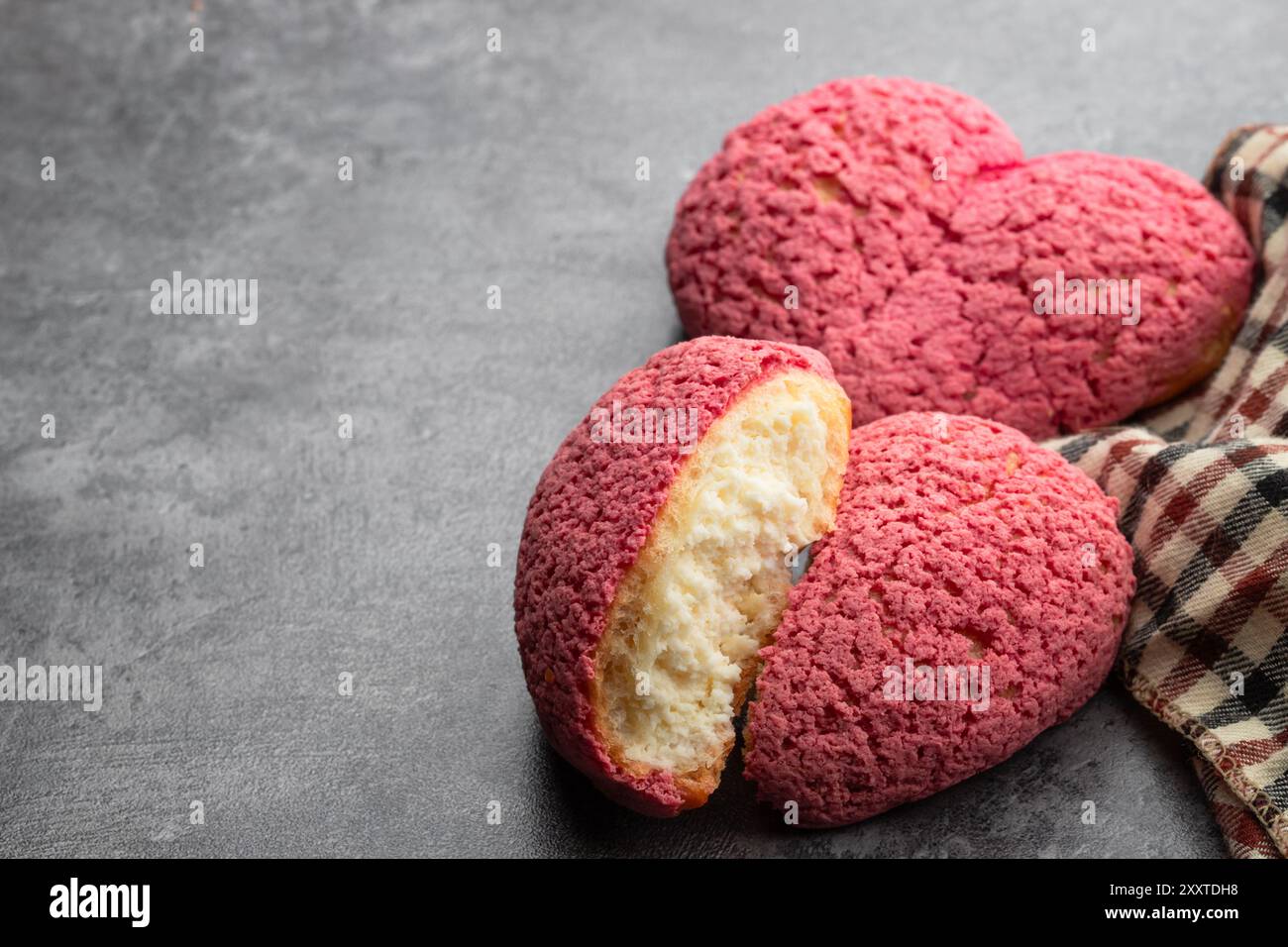 Herzförmige Choux-Kekse mit Cremefüllung auf grauem Hintergrund Stockfoto Herzförmige Choux-Kekse mit Cremefüllung auf grauem Hintergrund Stockfoto