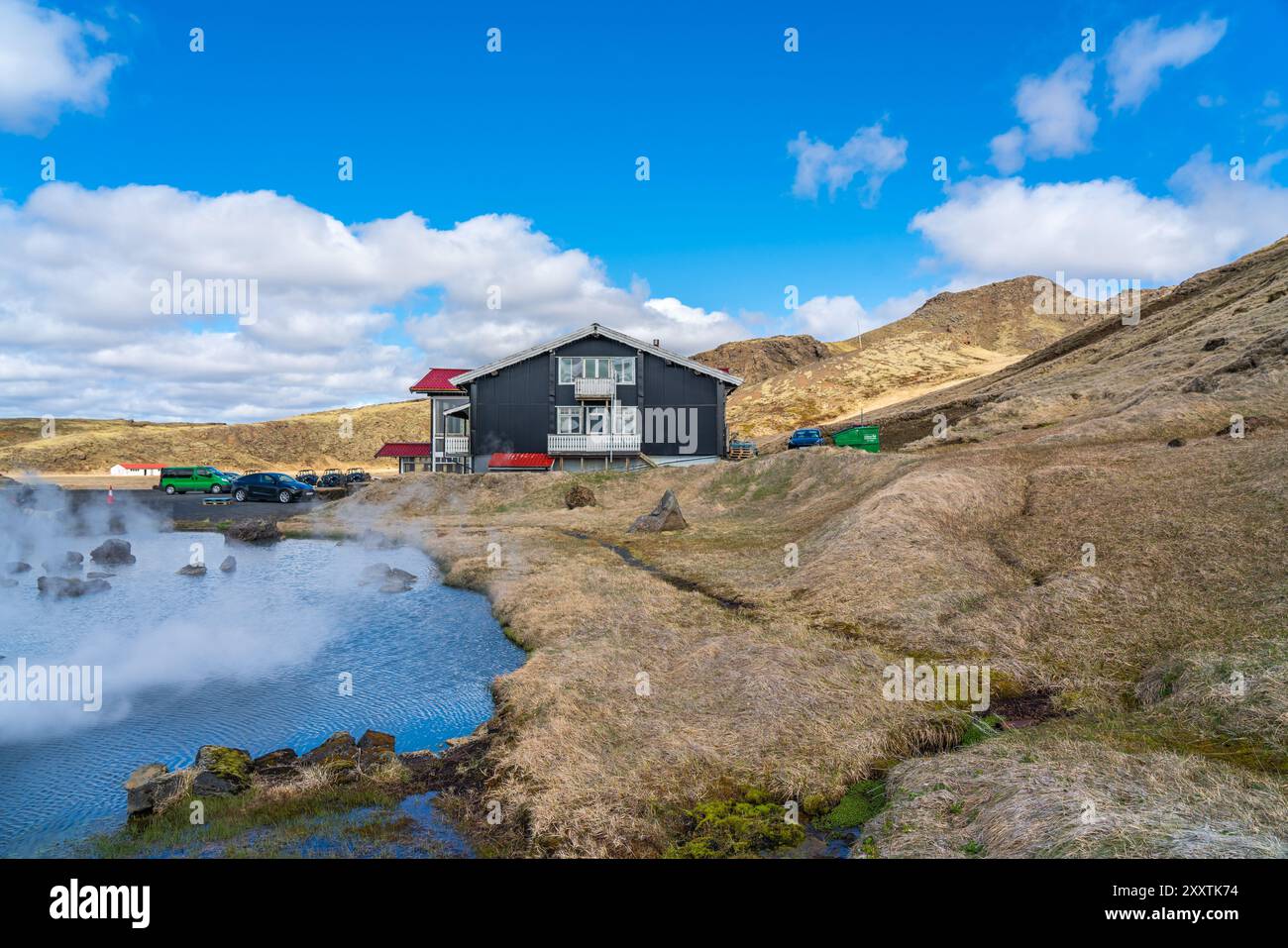 Das geothermische Gebiet von Hveradalir in Island an einem sonnigen Frühlingstag mit Wolken und blauem Himmel Stockfoto