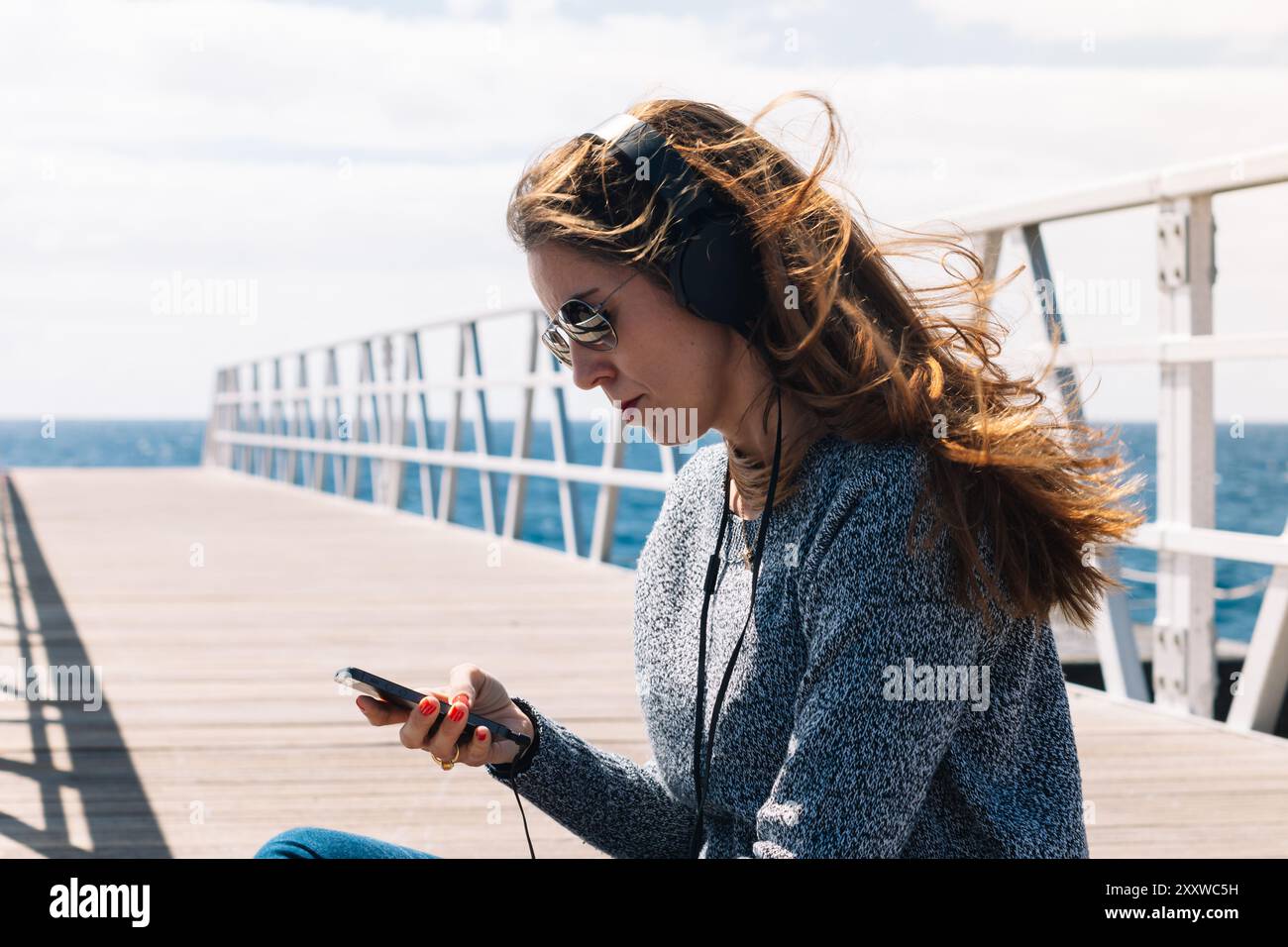 Frau, die Musik mit ihrem Handy hört Stockfoto