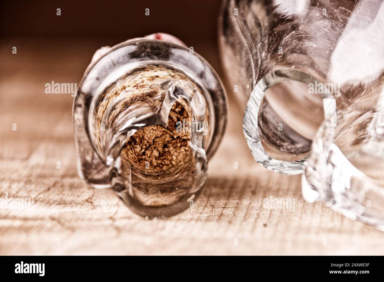 Kaputte Glasflasche mit Kork auf Holztisch, Nahaufnahme, kaputte Struktur Stockfoto