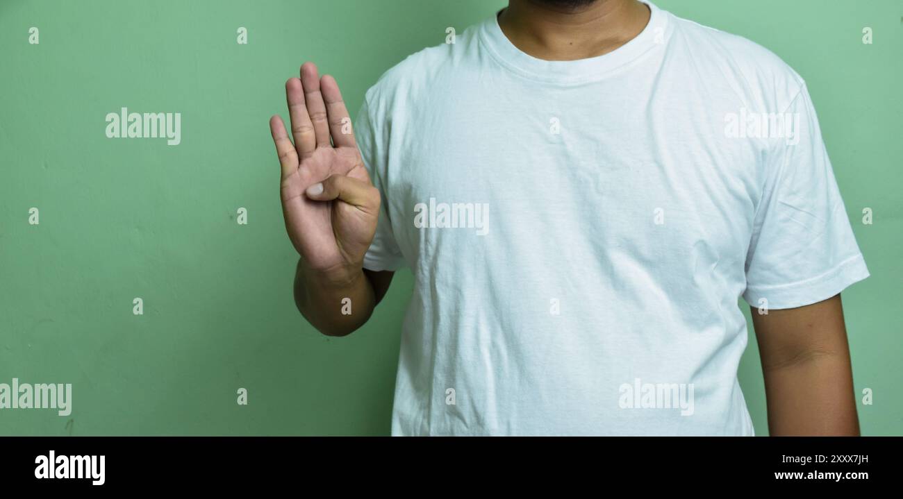 Junger Mann lernt taubes Alphabet und bildet mit erhobener Hand den Buchstaben B Stockfoto