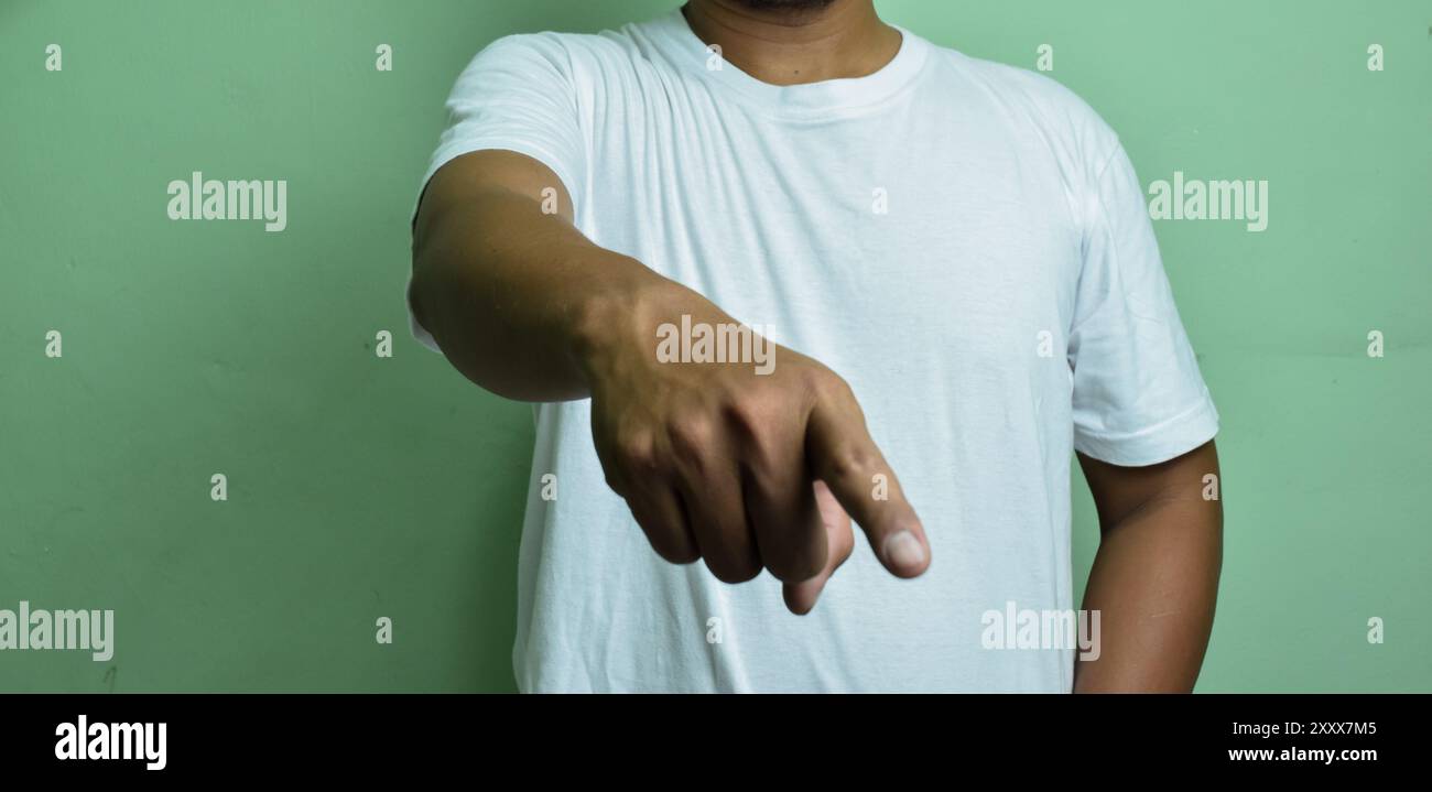 Männliche Hand zeigt unten isoliert auf grünem Hintergrund Stockfoto