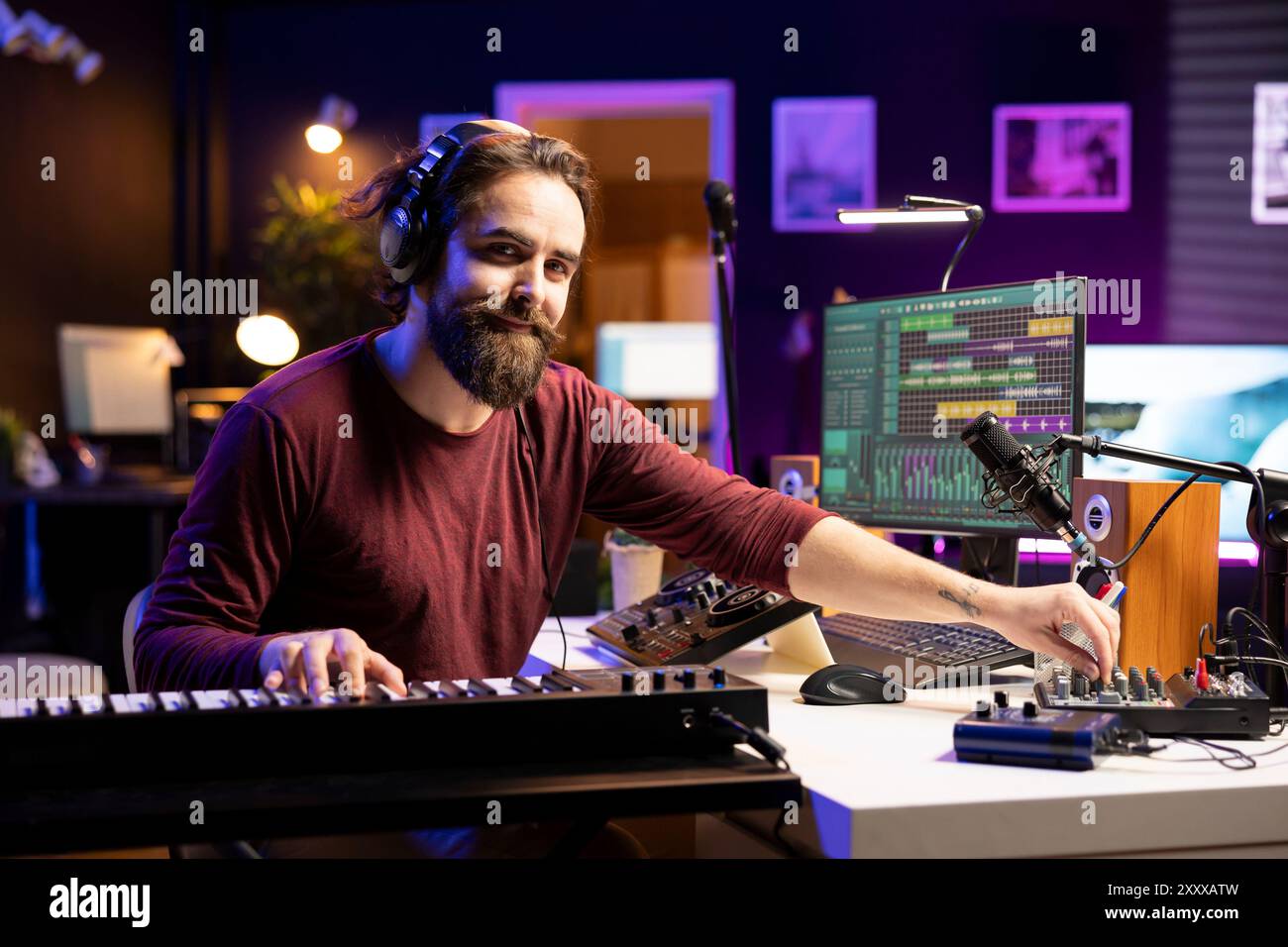 Porträt eines männlichen Sängers, der elektronische Keyboardnoten spielt und sie in einen neuen Soundtrack einfügt, wobei die daw-Software zum Bearbeiten von Songs verwendet. Komponist Songwriter, der Musik mit Synthesizer-Tasten erstellt. Stockfoto