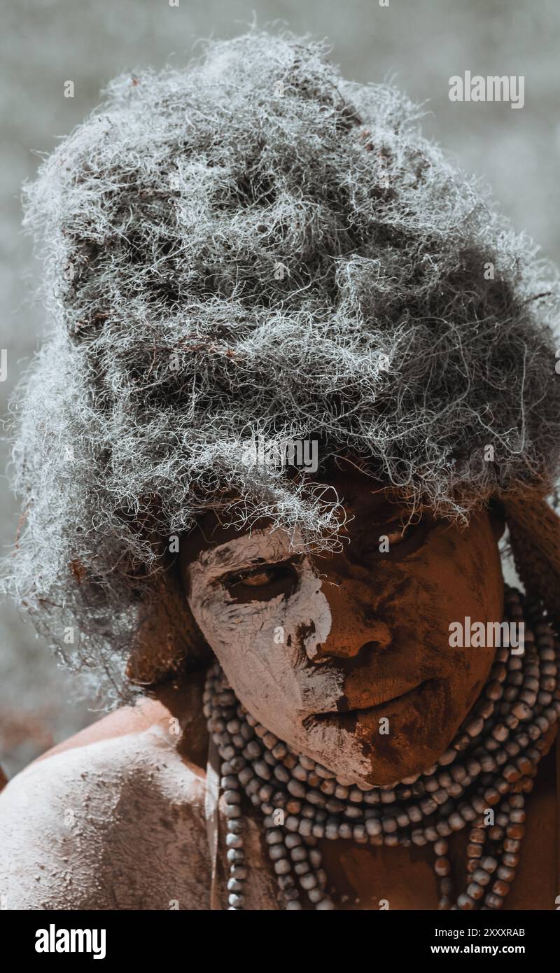 Der Coming-of-Age-Tanz eines Papua-Neuguineas Highlanders mit einem einzigartigen Kostüm aus halb braunem Ton und halb weißer Farbe markiert eine neue Hausfeier mit Stockfoto