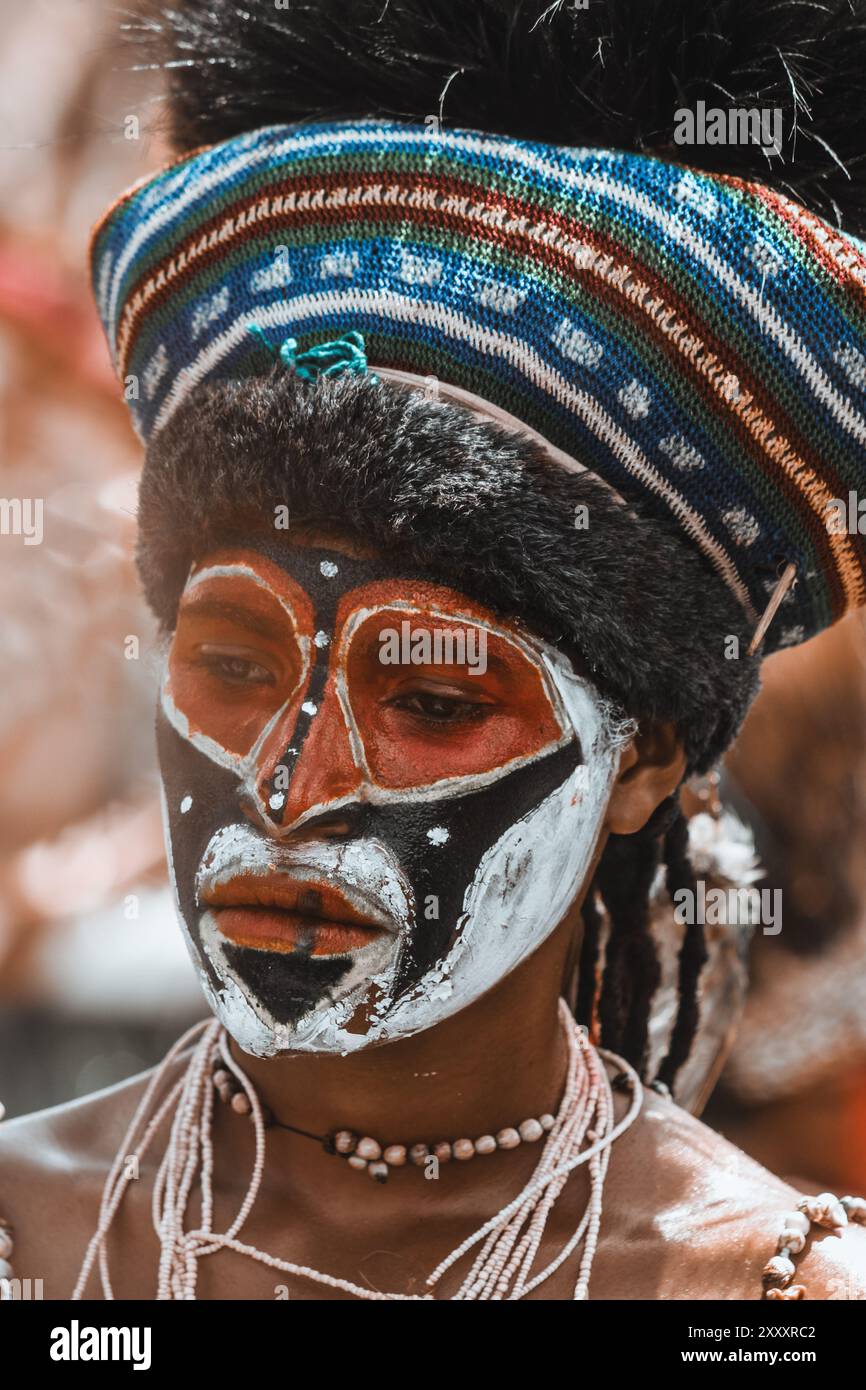 Eine Frau aus dem Hochland in Papua-Neuguinea, die in lebendigen traditionellen Gewändern gehalten ist und die reichen Farben und das kulturelle Erbe ihrer Region zeigt. Stockfoto