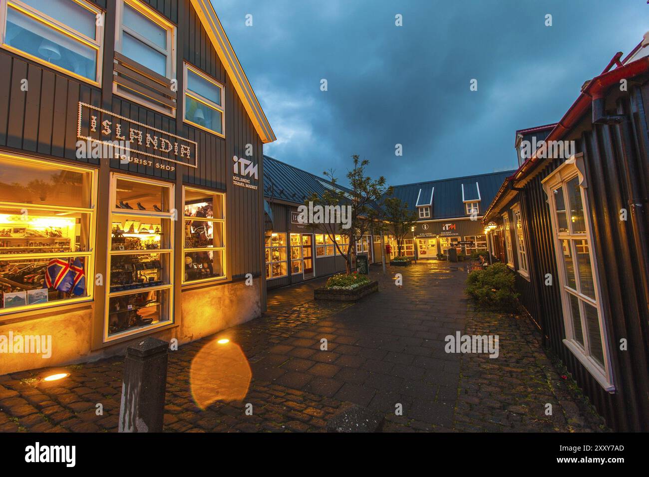 REYKJAVIK, ISLAND, 06. JULI: Kringlan Shopping Mall beleuchtet bei Nacht mit dem Islandia Souvenir Shop im Vordergrund in Reykjavik, Island auf Ju Stockfoto