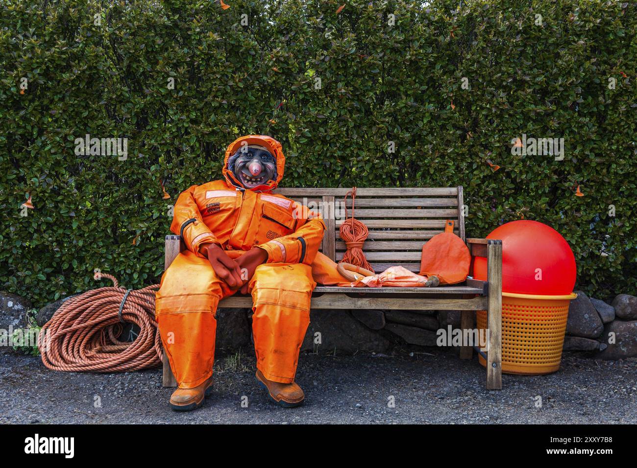 DJUPIVOGUR, ISLAND, 21. JUNI: Dummy einer Hexe mit einem hässlichen und gruseligen Gesicht in einem orangen Overall sitzt am 21. Juni 2013 auf einer Holzbank in Djupivogur, Stockfoto