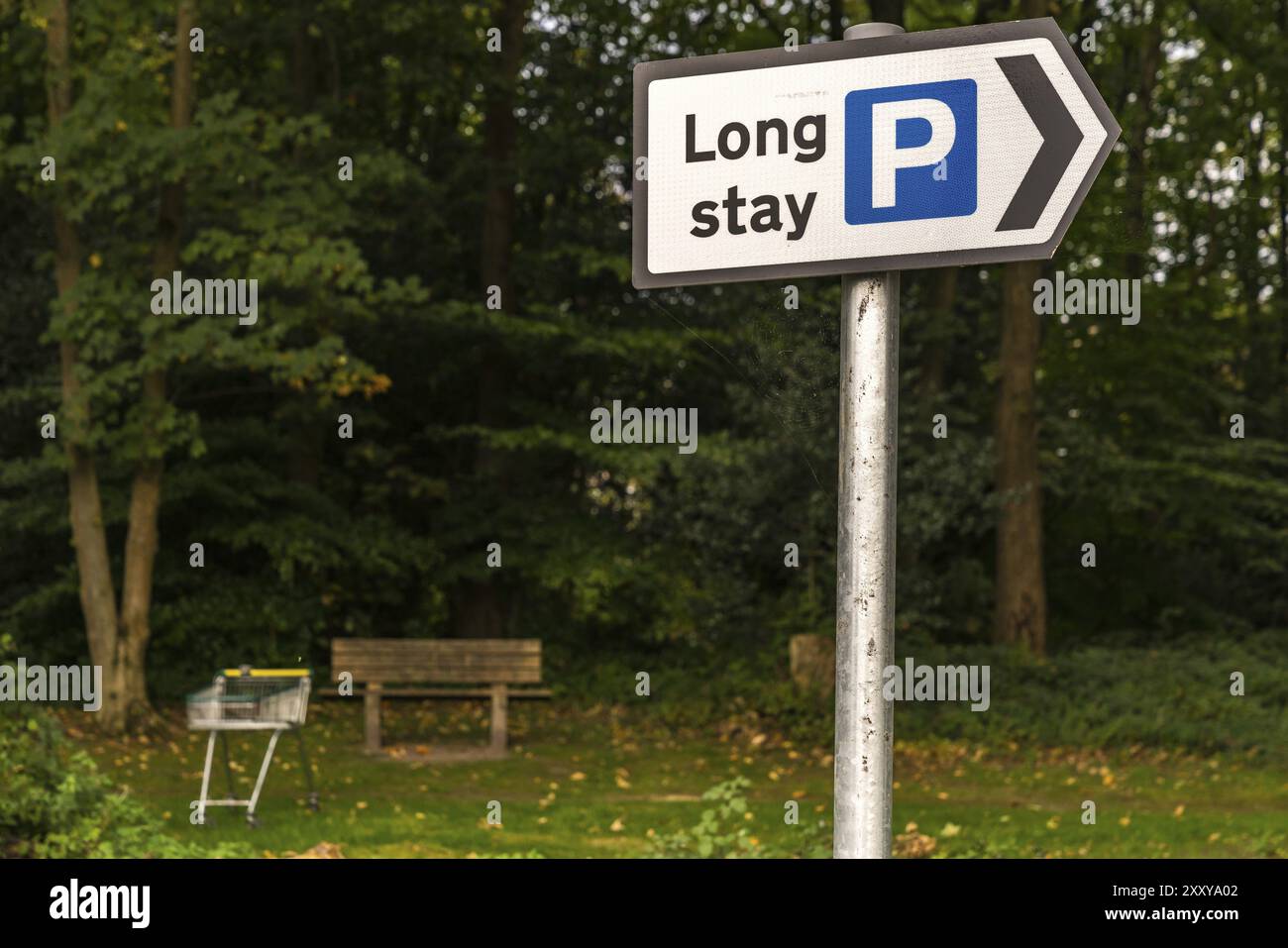 Schild: Parkplatz für lange Aufenthalte, mit Bank und Einkaufswagen im Hintergrund, gesehen in Crowborough, East Sussex, England, Großbritannien Stockfoto