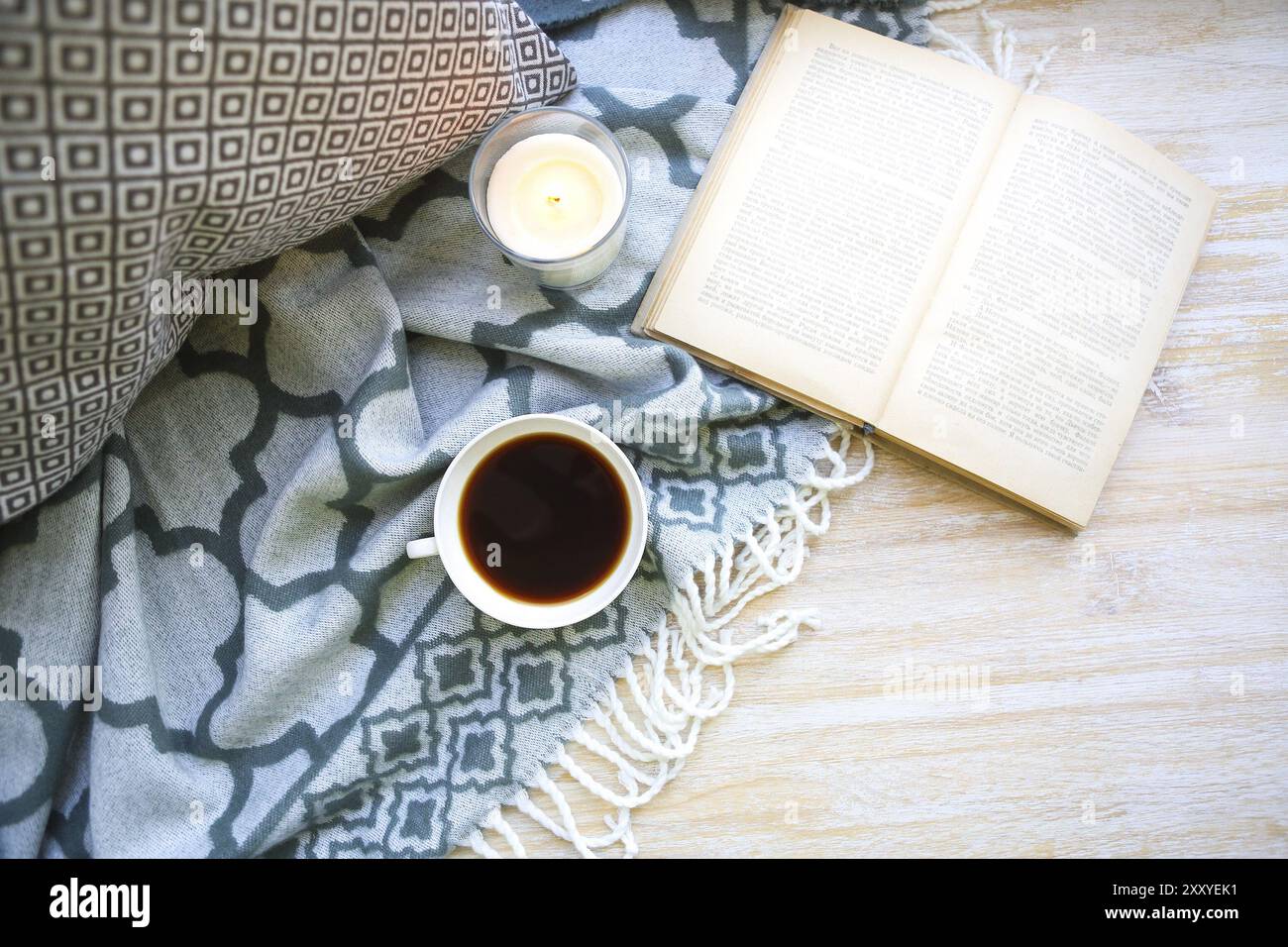 Tasse Kaffee, Kerze und Buch auf dem Holzboden Stockfoto