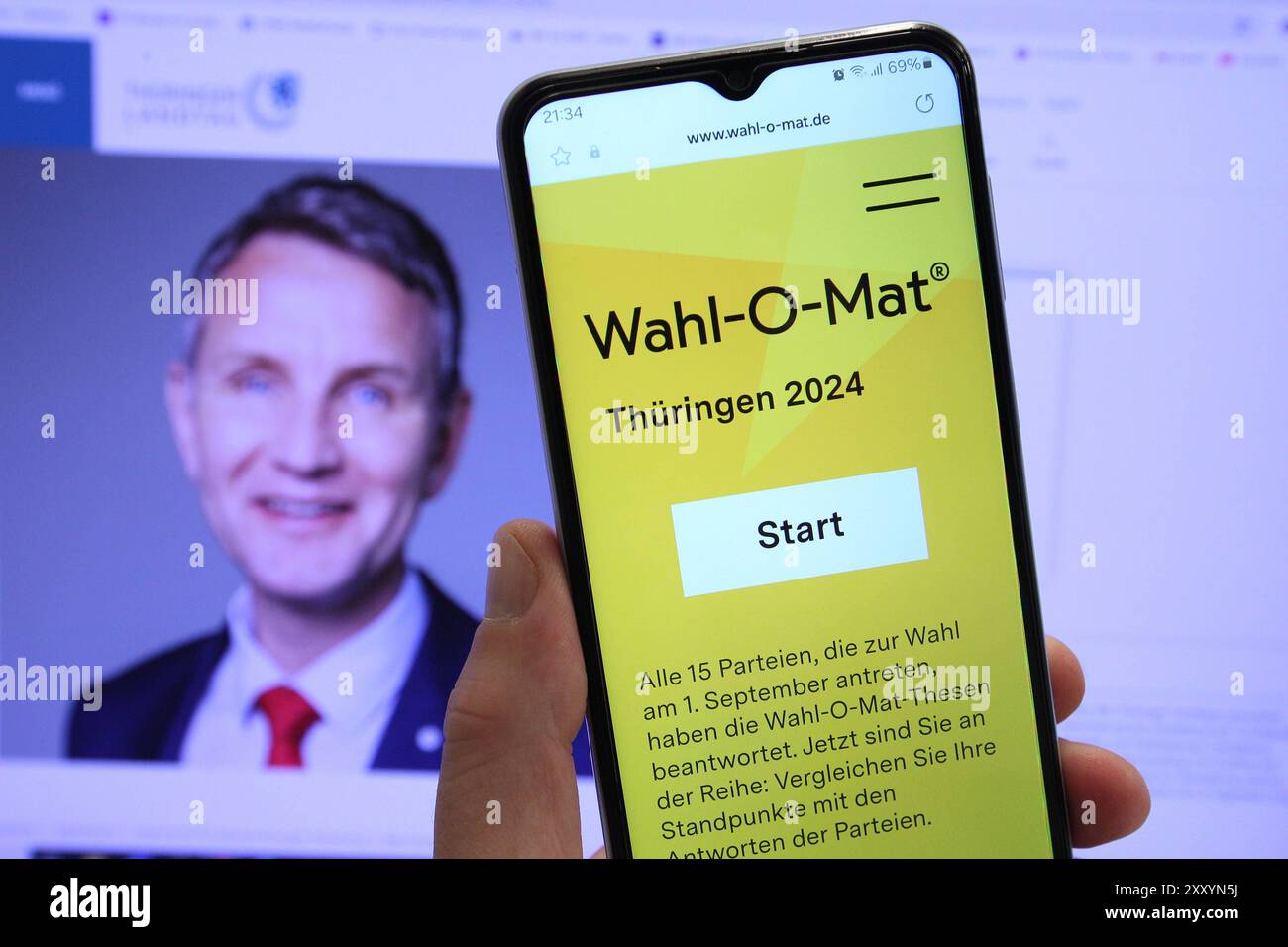 Auf einem Smartphone war der Wahl-O-Mat für die Landtagswahl in Thüringen geöffnet. Dahinter ist auf einem Bildschirm der Spitzenkandidat der Alternative für Deutschland AfD für die Wahl, Björn Höcke, zu sehen. Schnelsen Hamburg *** die Wahl O Mat für die Landtagswahl in Thüringen wurde auf einem Smartphone dahinter geöffnet, der Spitzenkandidat der AfD für die Wahl, Björn Höcke, ist auf einem Bildschirm Schnelsen Hamburg zu sehen Stockfoto