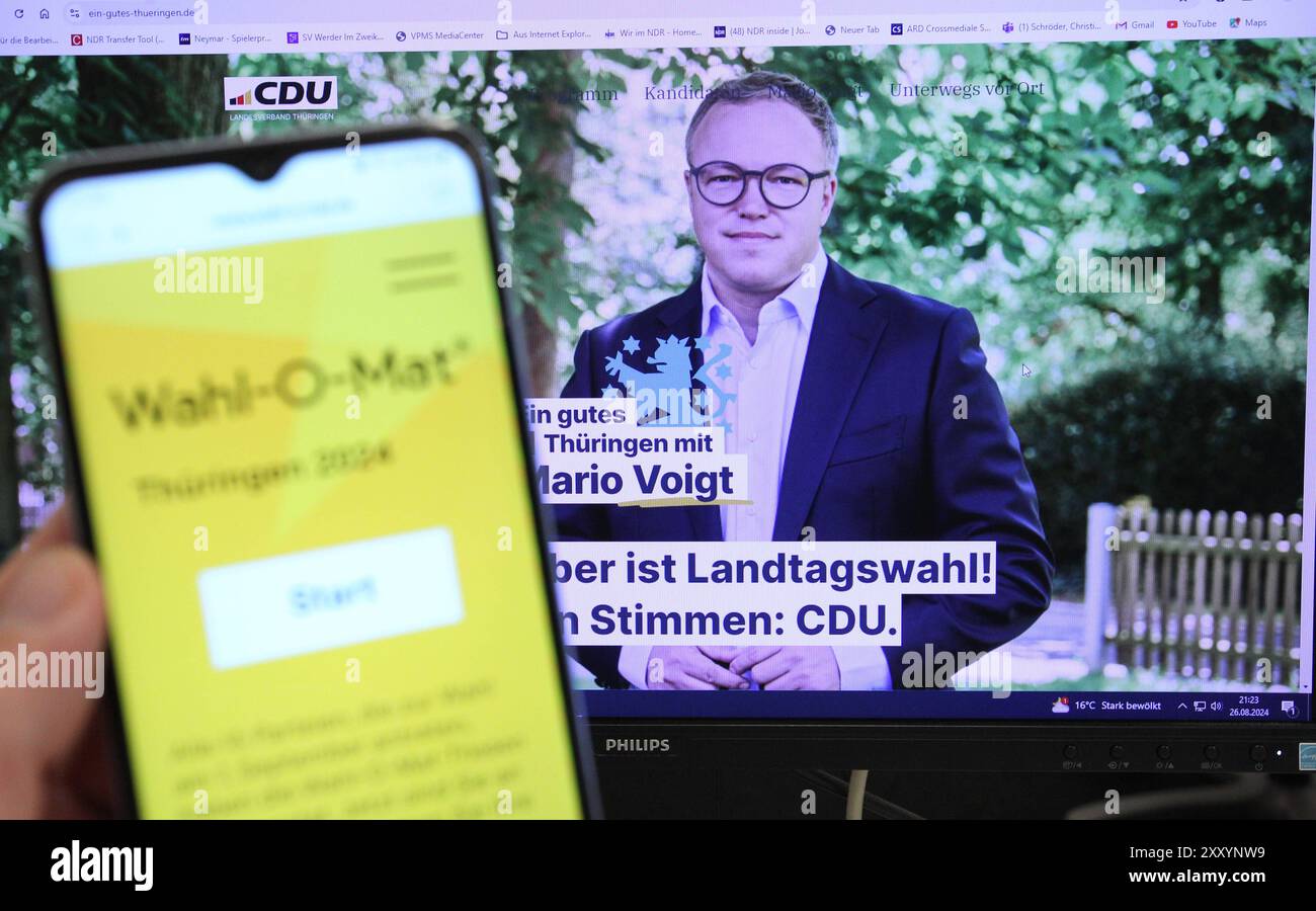 Auf einem Smartphone war der Wahl-O-Mat für die Landtagswahl in Thüringen geöffnet. Dahinter ist auf einem Bildschirm der Spitzenkandidat der CDU für die Wahl, Mario Voigt, zu sehen. Schnelsen Hamburg *** die Wahl O Mat für die Landtagswahl in Thüringen wurde auf einem Smartphone dahinter geöffnet, der CDU-Spitzenkandidat Mario Voigt ist auf einem Bildschirm Schnelsen Hamburg zu sehen Stockfoto