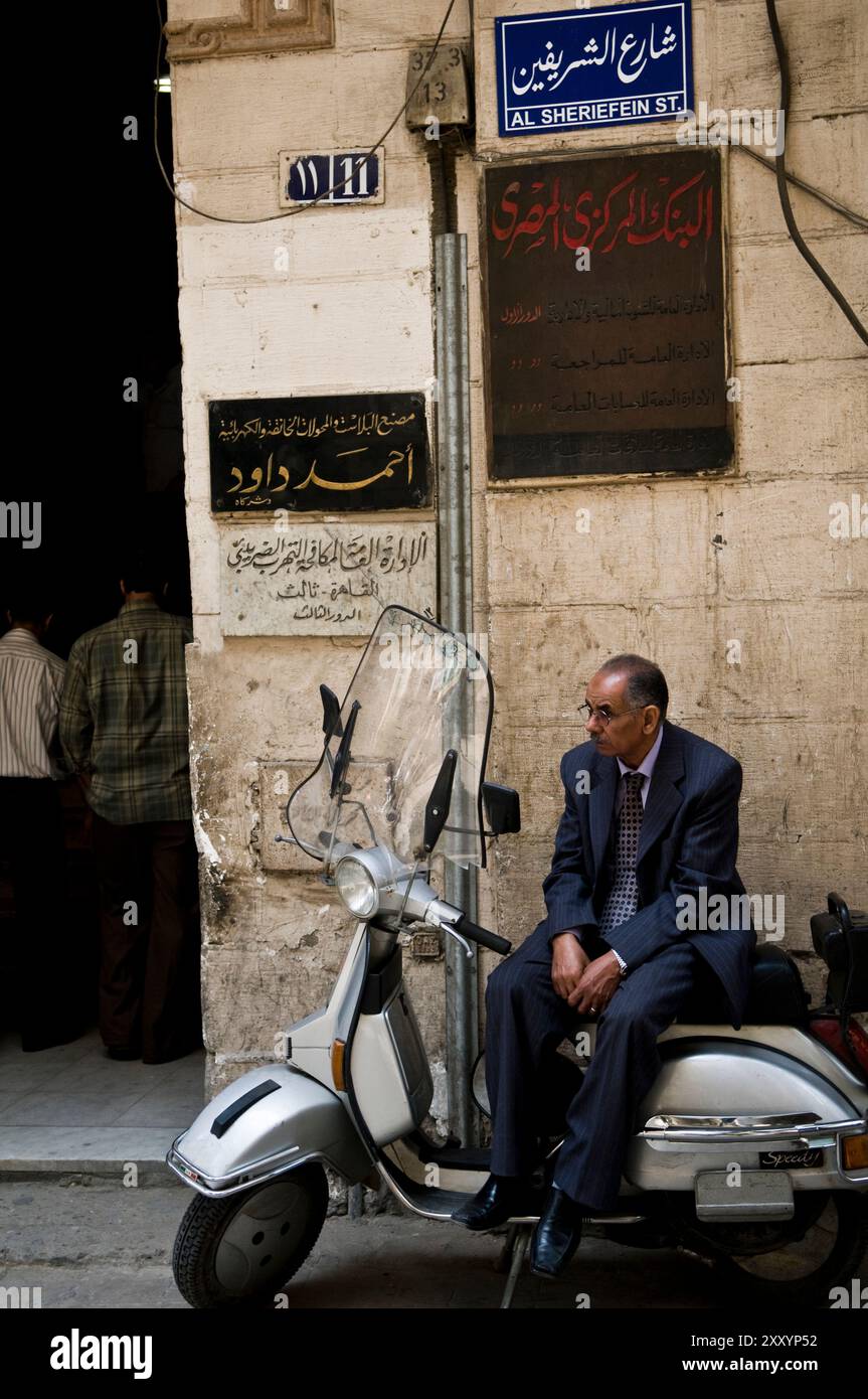 Ein ägyptischer Mann sitzt auf seinem Roller. Al Sheriefein Street, Kairo, Ägypten. Stockfoto