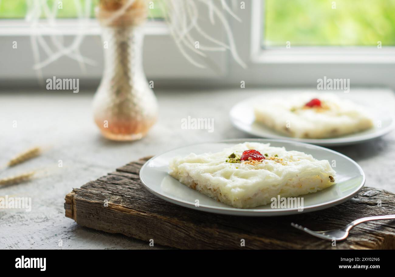 Traditionelles türkisches Ramadan-Dessert Gullac, milchiges Dessert mit Pistazienpulver und Erdbeermarmelade, ottomanische Küche Stockfoto