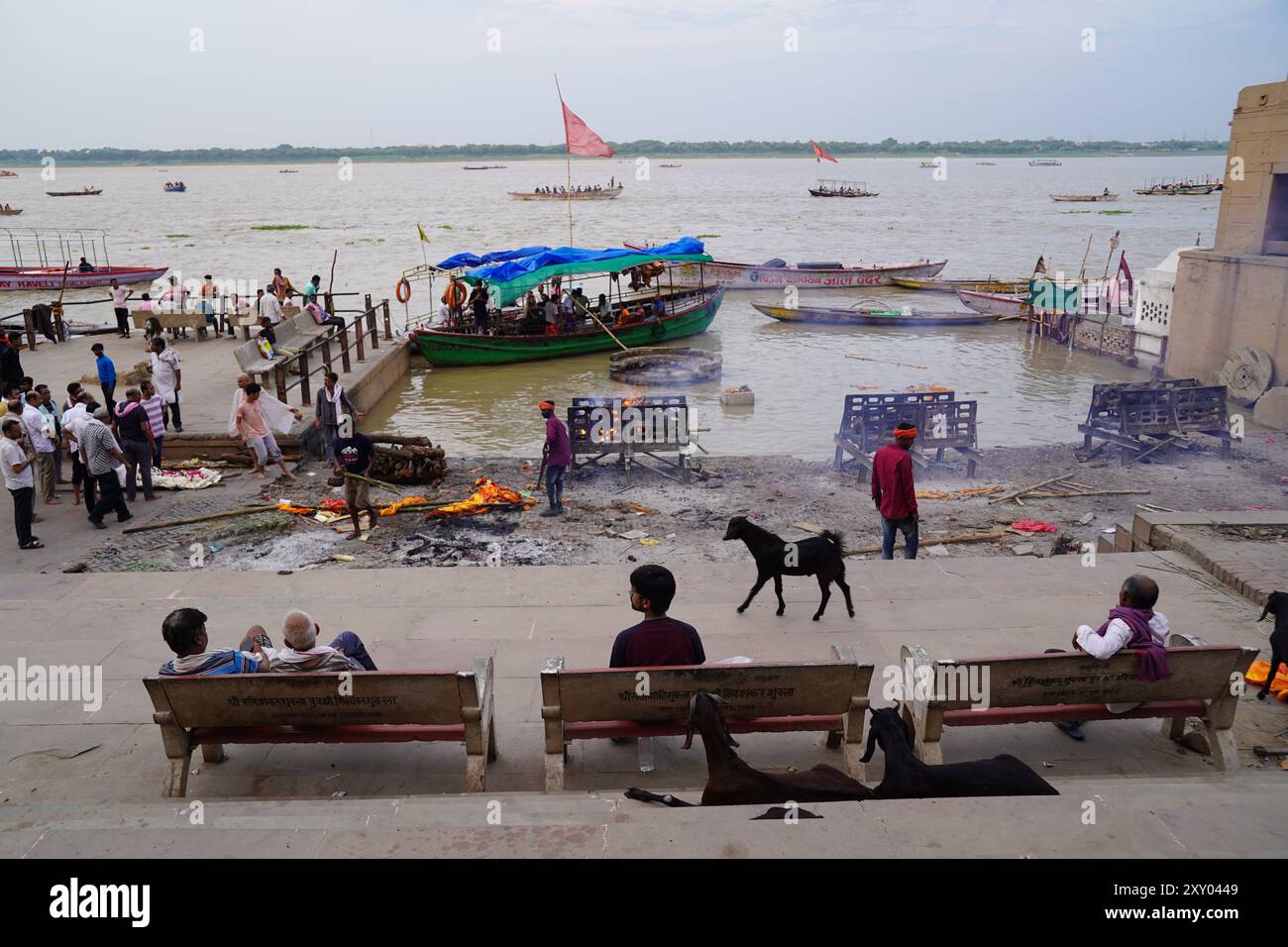 Varanasi, Indien. Juli 2024. Verwandte und andere Leute beobachten, wie Leichen von den Ganges verbrannt werden. Viele Hindus glauben, dass man dem ewigen Zyklus der Wiedergeburt entfliehen und Erlösung erreichen kann, wenn man in Waransi stirbt oder dort verbrannt wird. Quelle: Anne-Sophie Galli/dpa/Alamy Live News Stockfoto