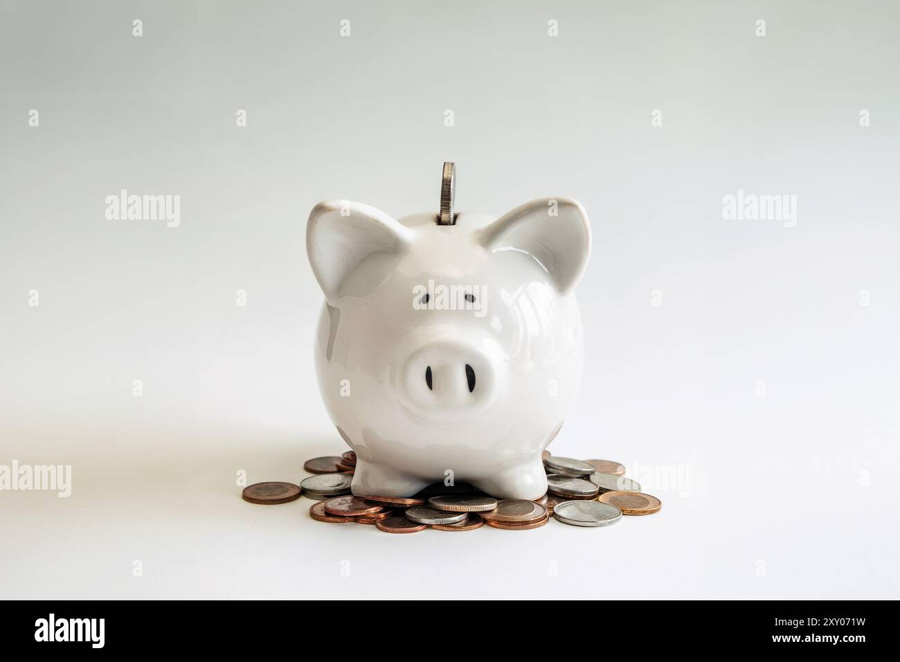 Eine unberührte weiße Keramik-Schweinebank sitzt mittig im Rahmen und symbolisiert den Akt des Sparens. Generatives KI-Bild Stockfoto