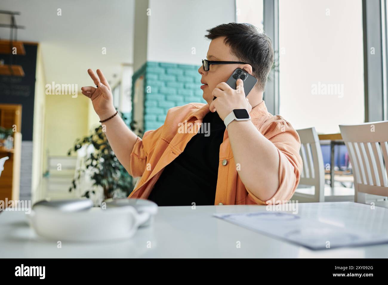 Ein Mann mit Down-Syndrom bestellt, während er telefoniert Stockfoto