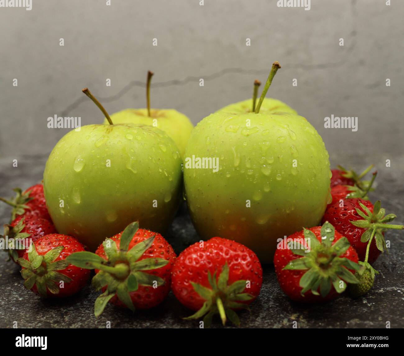 Vier Äpfel und acht Erdbeeren frisch und verzehrfertig Stockfoto