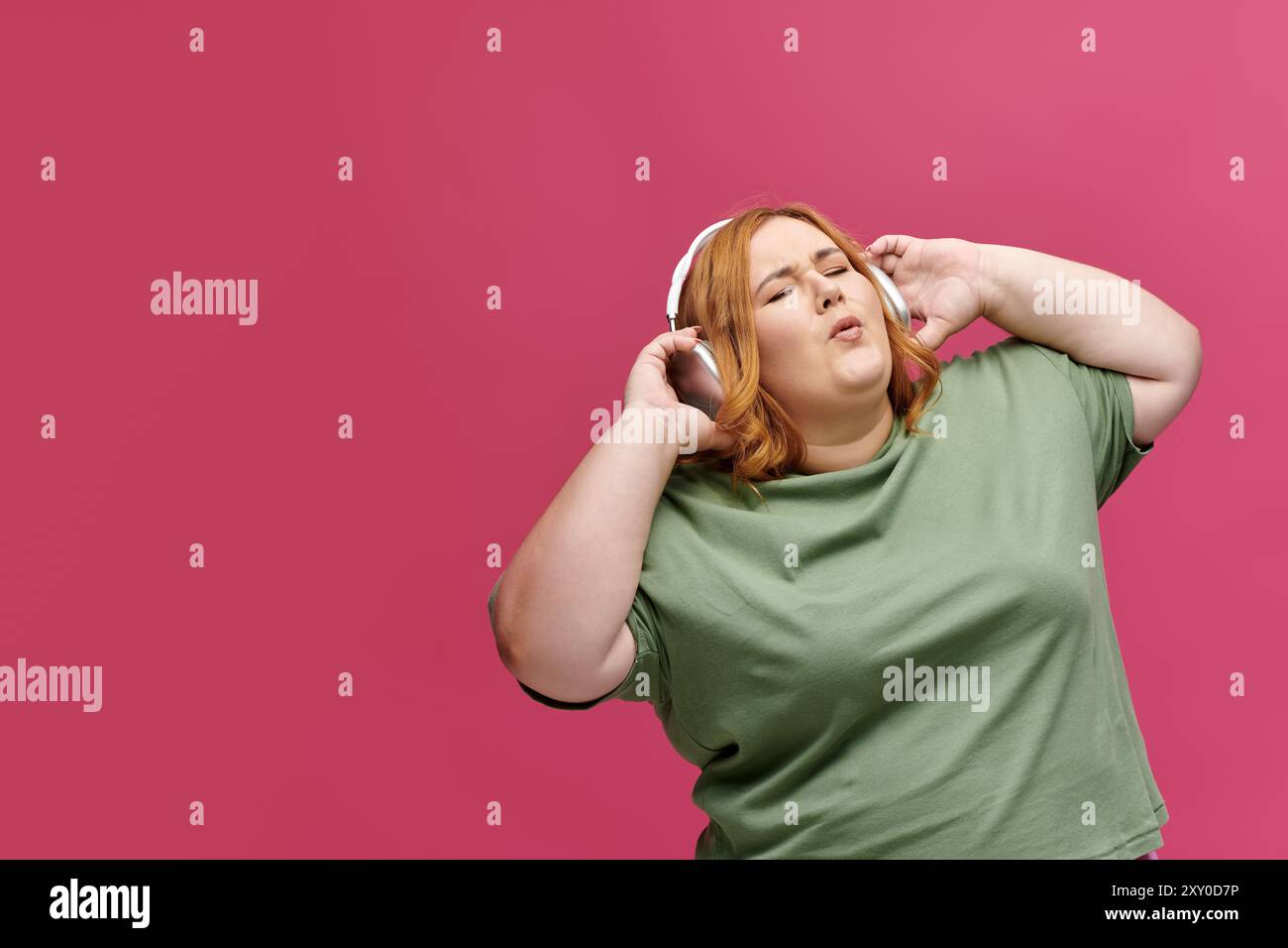 Eine Frau mit Kopfhörern tanzt mit geschlossenen Augen. Stockfoto