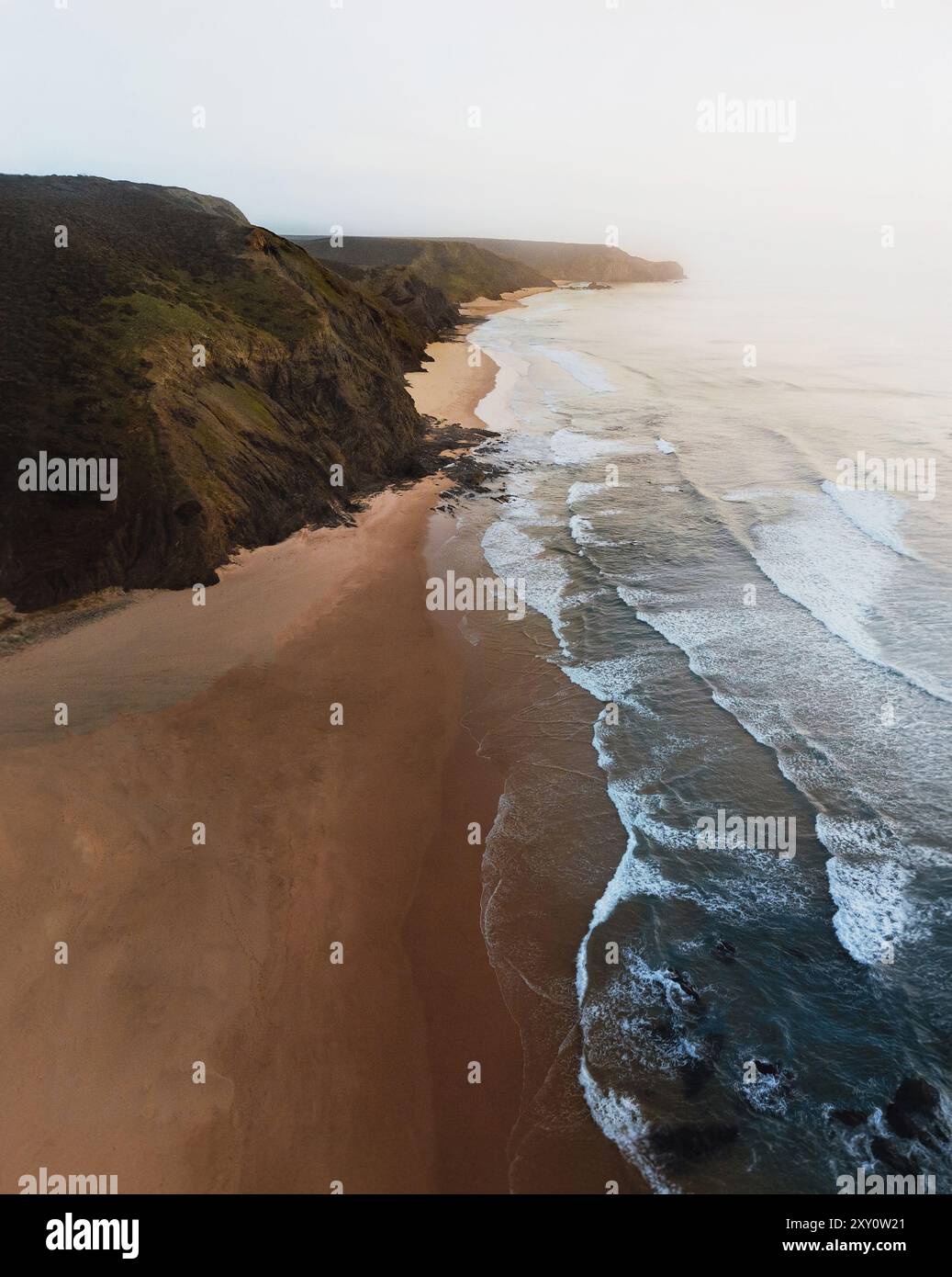 Von oben treffen die Küsten auf die Sandstrände der Algarve bei Sonnenuntergang in dieser ruhigen Landschaft Portugals. Stockfoto
