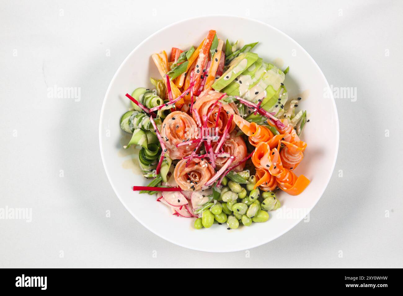 Blick von oben auf die Salmon Poke Bowl mit Lachs und Avocado auf weißem Hintergrund Stockfoto