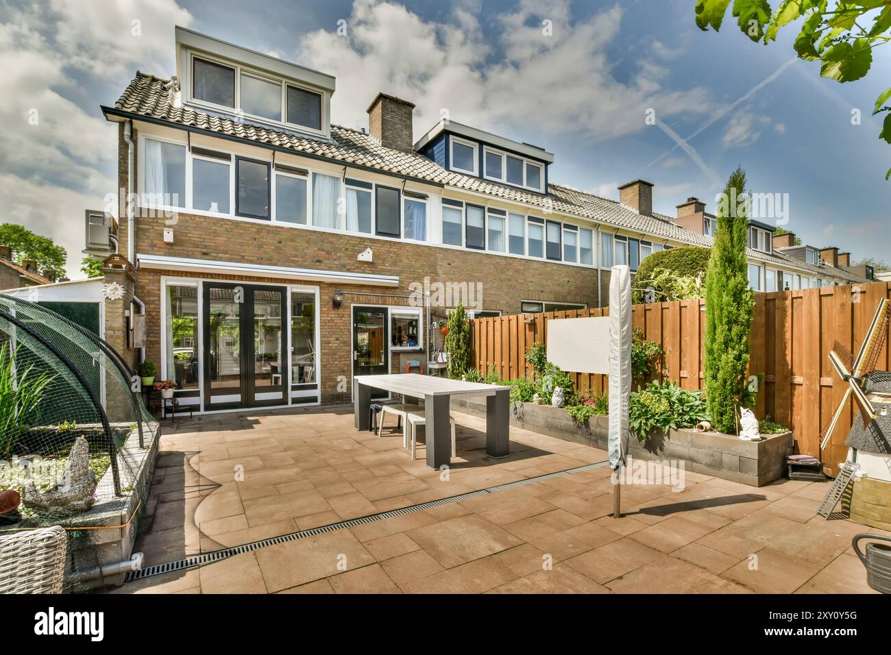 Ein geräumiger Vorort-Hinterhof mit gepflasterter Terrasse, Gartenbereich und familienfreundlicher Außenanlage. Stockfoto