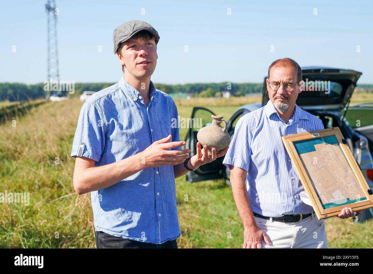 Prof Dr Markus Scholz von der Goethe-Uni Frankfurt R. erzählt von den Ausgrabungen, mit Mitarbeiter Niklas Schanz, der einen ausgegrabenen Henkelkrug zeigt - Nauheim 27.08.2024: Präsentation Ergebnisse von Ausgrabungen einer Grabstelle aus der Römerzeit *** Prof Dr. Markus Scholz von der Goethe-Universität Frankfurt r spricht über die Ausgrabungen, mit Mitarbeiter Niklas Schanz, der einen ausgegrabenen Henkelkrug Nauheim 27 08.2024 Präsentation der Grabungsergebnisse aus der römischen Grabungszeit Stockfoto