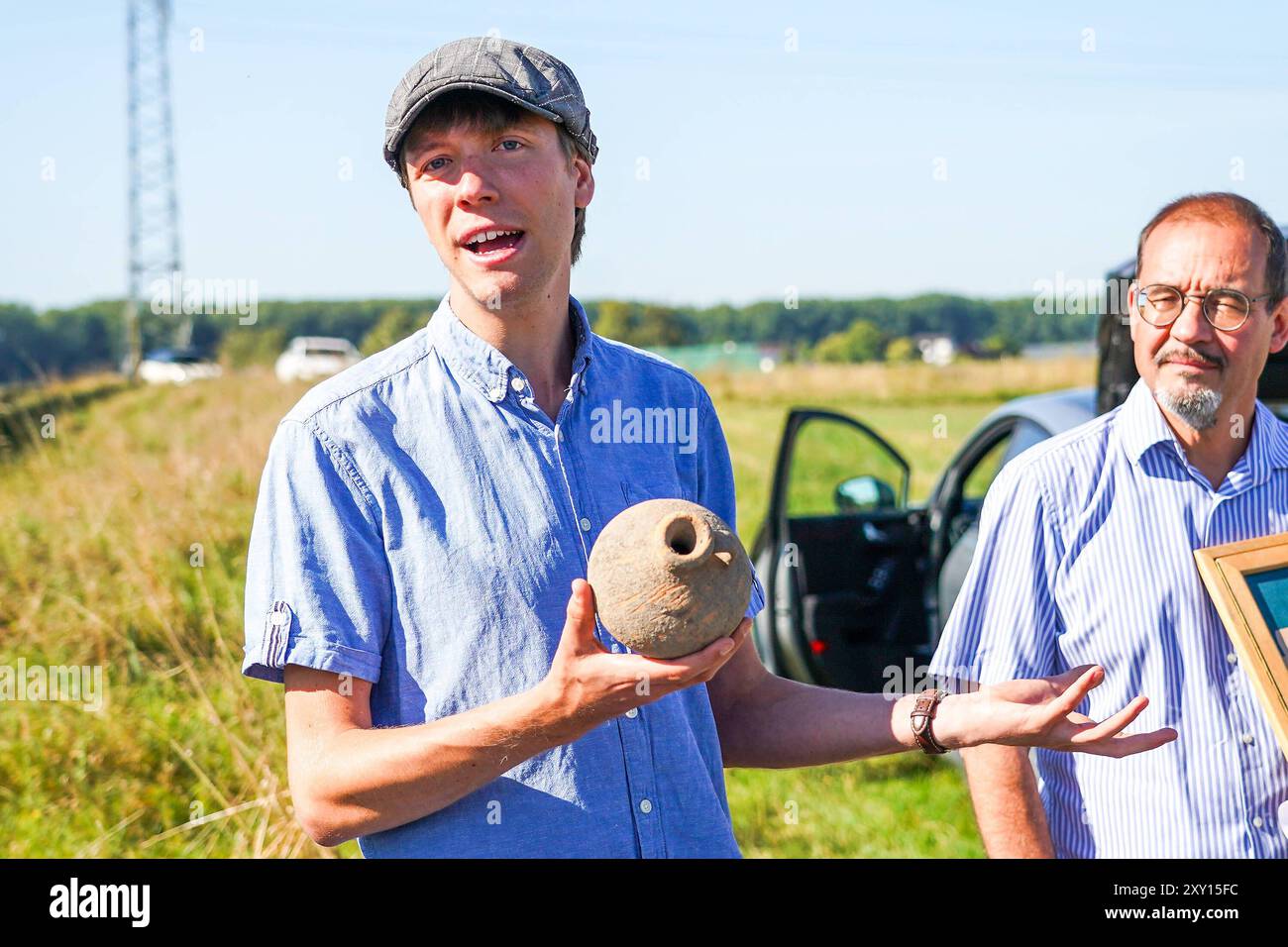 Prof Dr Markus Scholz von der Goethe-Uni Frankfurt R. erzählt von den Ausgrabungen, mit Mitarbeiter Niklas Schanz, der einen ausgegrabenen Henkelkrug zeigt - Nauheim 27.08.2024: Präsentation Ergebnisse von Ausgrabungen einer Grabstelle aus der Römerzeit *** Prof Dr. Markus Scholz von der Goethe-Universität Frankfurt r spricht über die Ausgrabungen, mit Mitarbeiter Niklas Schanz, der einen ausgegrabenen Henkelkrug Nauheim 27 08.2024 Präsentation der Grabungsergebnisse aus der römischen Grabungszeit Stockfoto