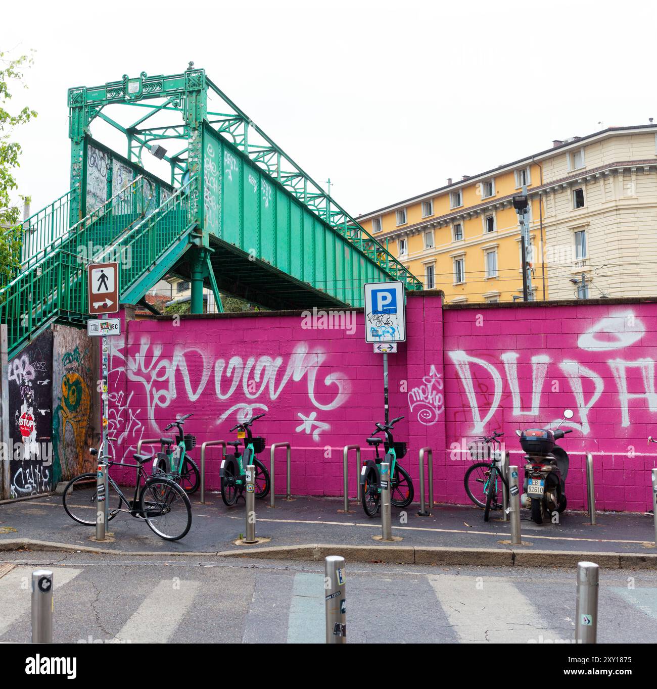 Mailand, Italien – 23. Juni 2024: Charakteristische grüne Metallbrücke neben einer Fuchsiemauer, die die Stadtteile Porta Genova und Tortona von Mailand verbindet, CLOO Stockfoto