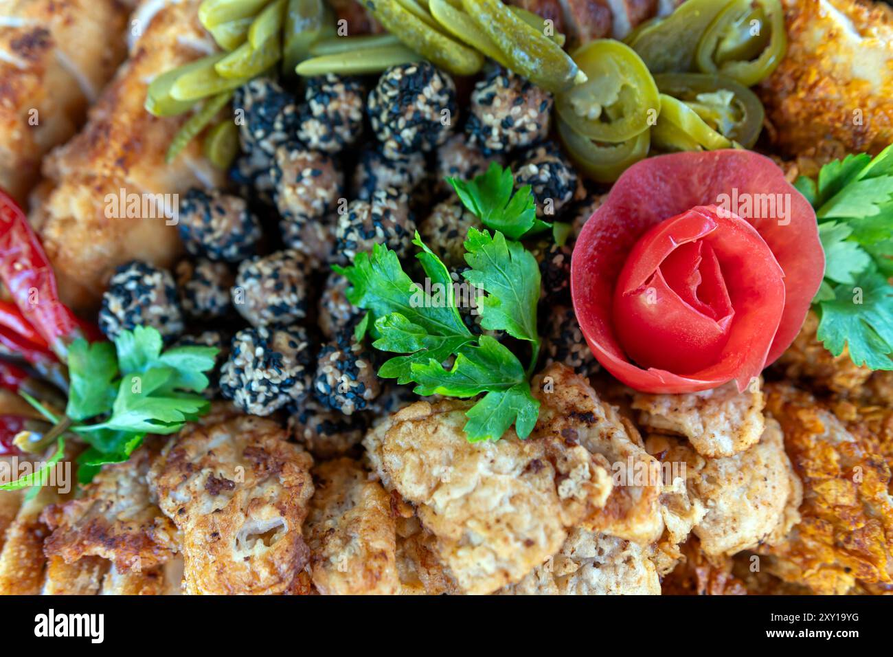 Eine farbenfrohe Auswahl an gegrillten und frittierten Fleischsorten mit Beilagen und Gemüse. Stockfoto