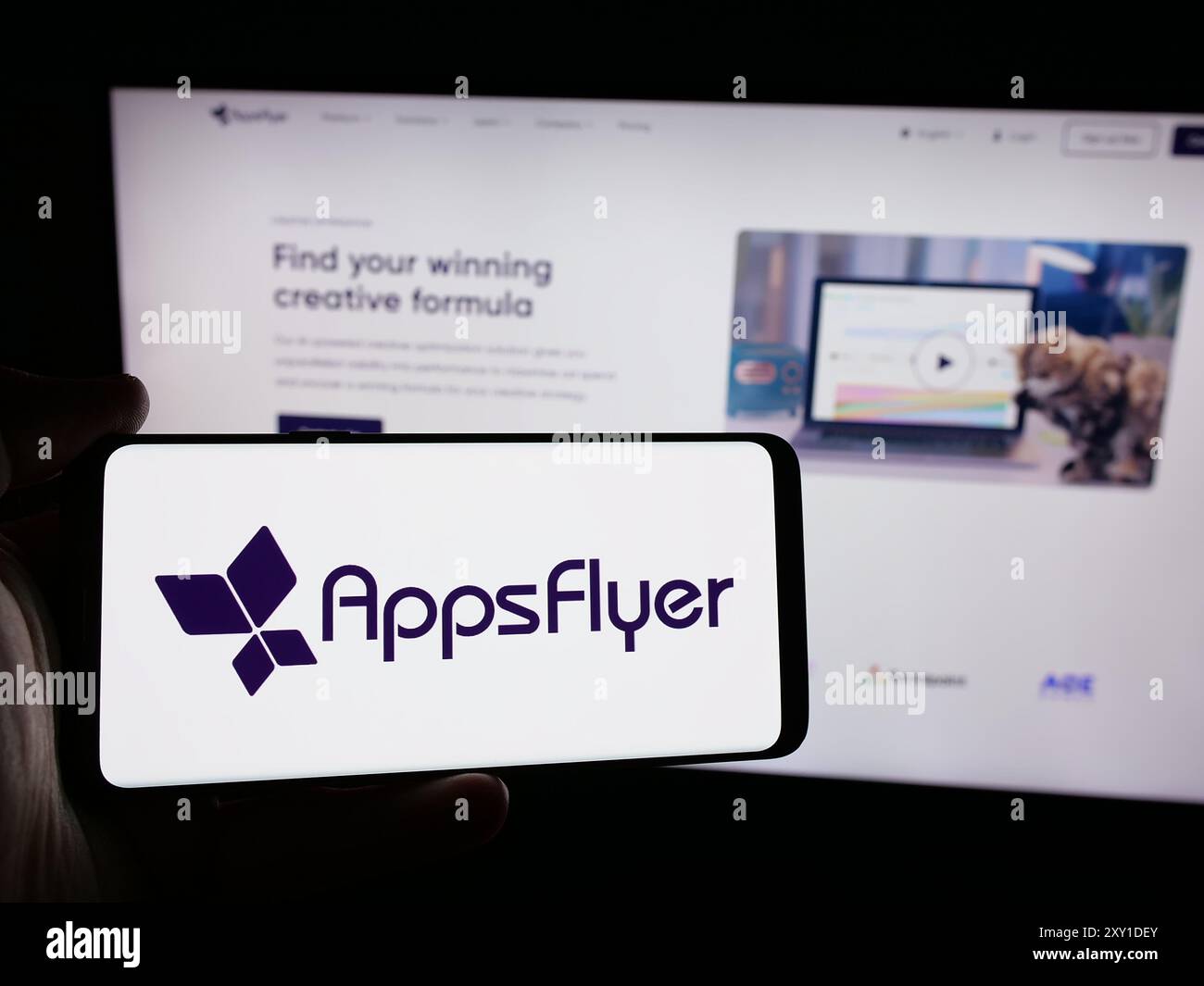 Person, die ein Smartphone mit dem Logo des US-amerikanischen Mobilmarketing-Unternehmens AppsFlyer Ltd. Vor der Website hält. Schwerpunkt auf dem Display des Telefons. Stockfoto Person, die ein Smartphone mit dem Logo des US-amerikanischen Mobilmarketing-Unternehmens AppsFlyer Ltd. Vor der Website hält. Schwerpunkt auf dem Display des Telefons. Stockfoto