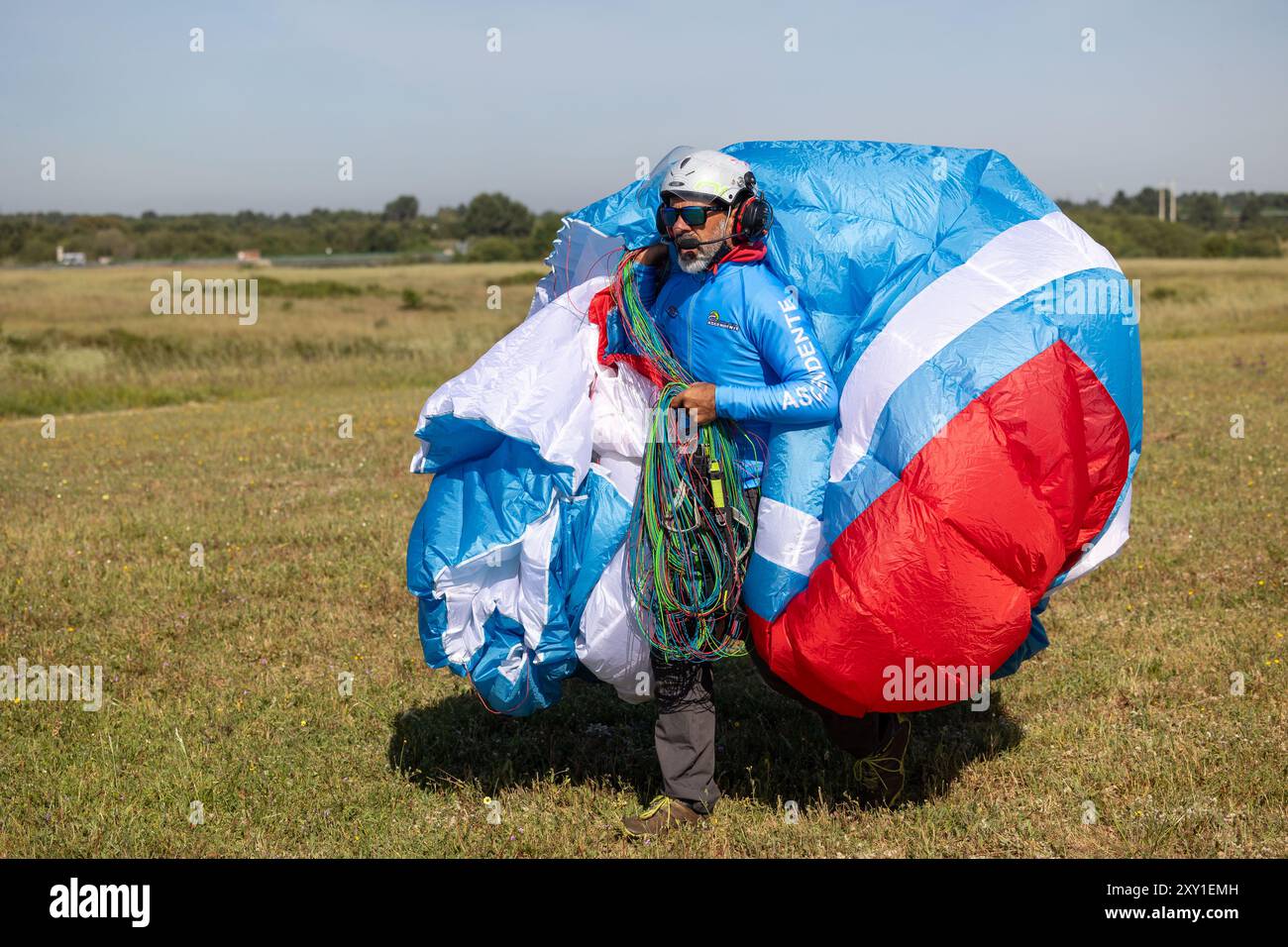 Gleitschirmflieger an Land mit Flügel. Stockfoto