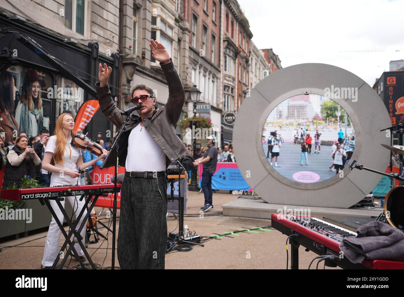 Cian Ducrot und Flash Mob Choir treten auf dem Dublin-Portal auf und streamen live nach New York, Vilnius und Lublin. Bilddatum: Dienstag, 27. August 2024. Stockfoto