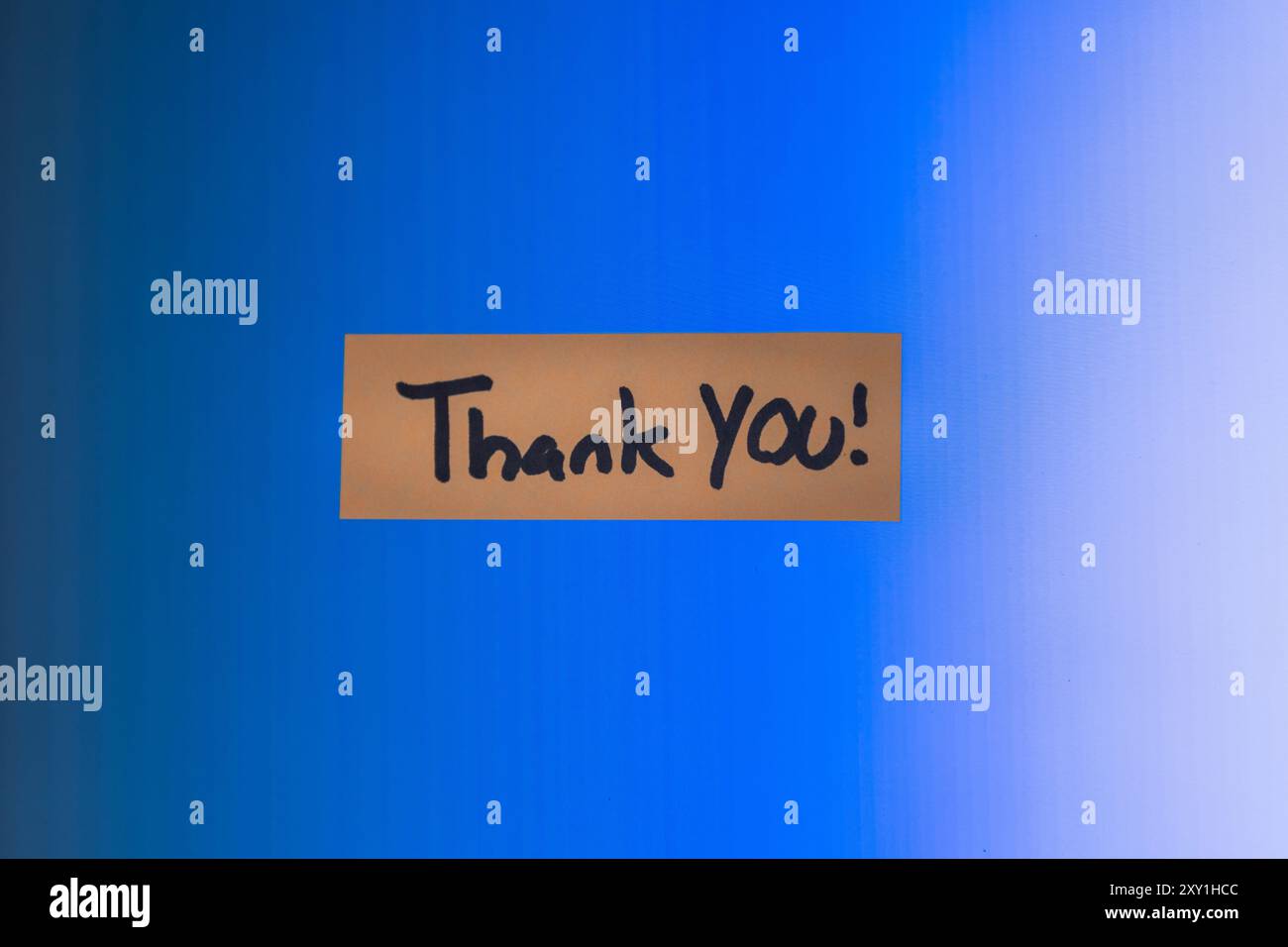 Ein Dankeschön auf einem Computerbildschirm. Die Notiz befindet sich auf einem blauen Hintergrund mit einer schweren Vignette Stockfoto