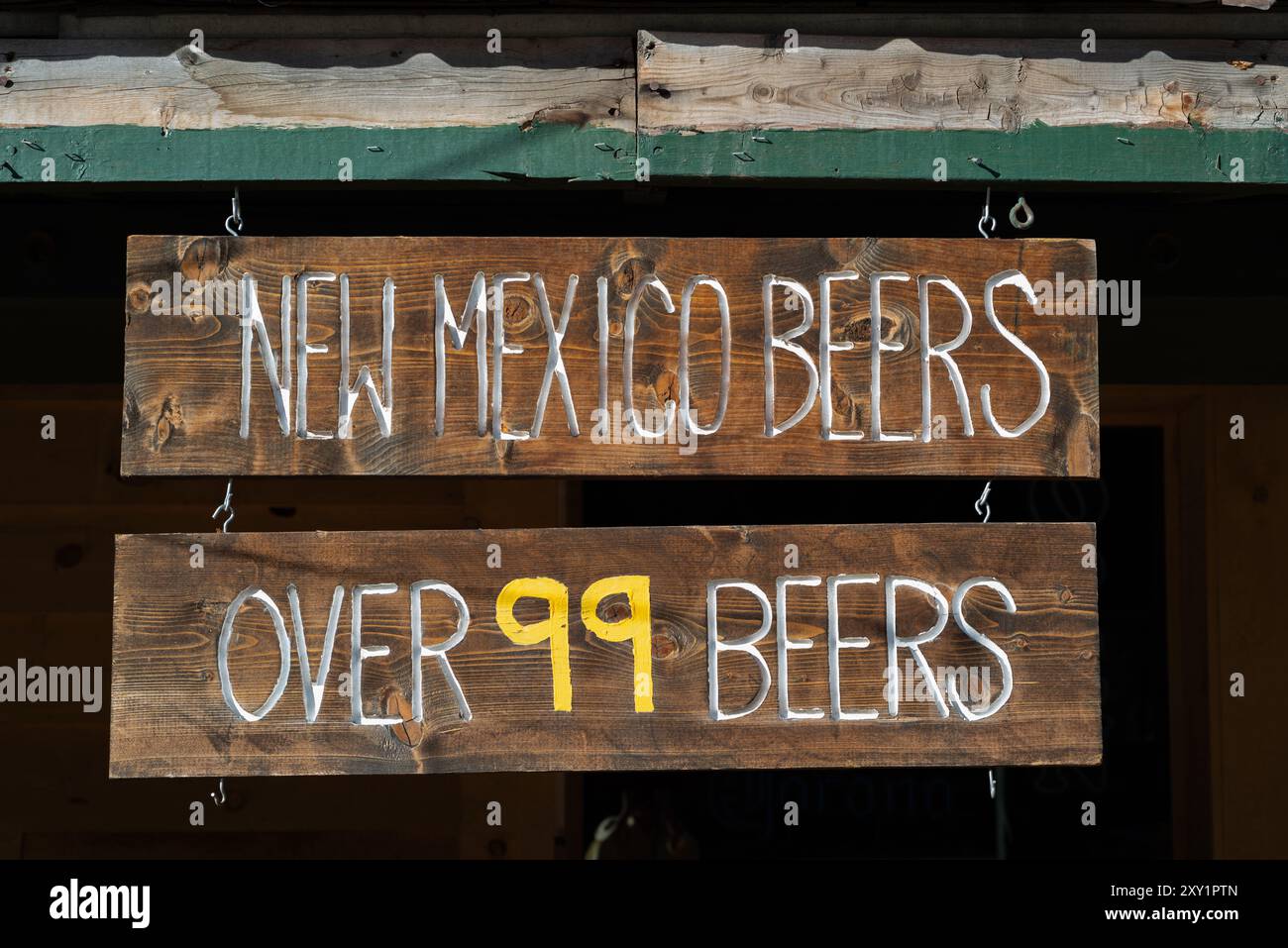 Schild mit der Aufschrift New Mexico Beers, über 99 Biere hängen an der alten Westfassade des Bull o the Woods Saloon in der kleinen Stadt Red River, New Mexico, USA. Stockfoto