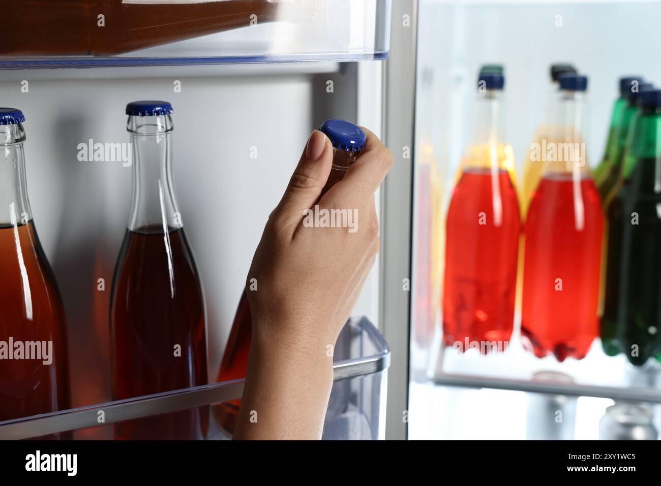 Frau nimmt Flasche mit Getränk aus dem Kühlschrank, Nahaufnahme Stockfoto