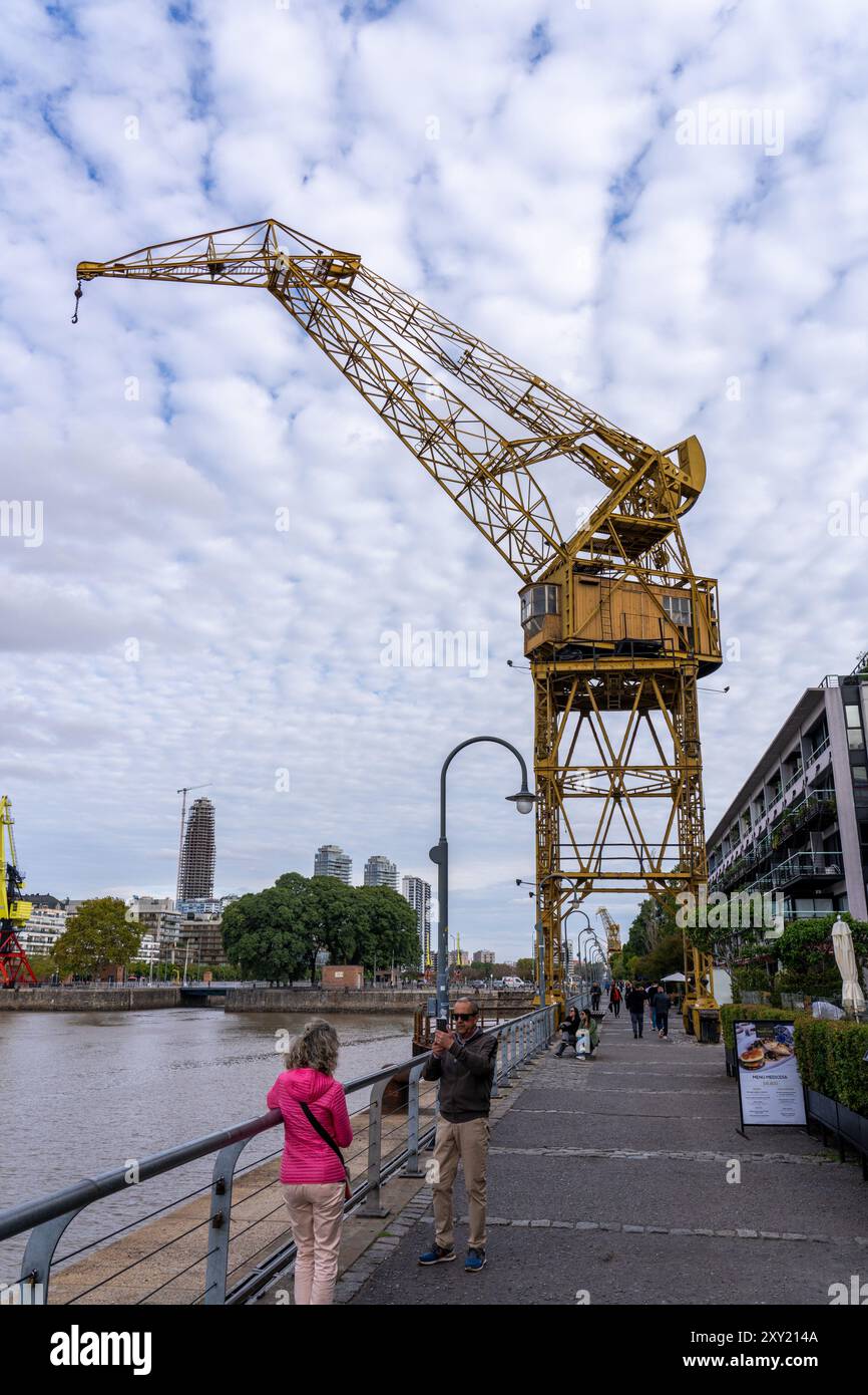 Touristen machen ein Foto vor einem pensionierten Portalkran in den ehemaligen Docks von Puerto Madero, Buenos Aires, Argentinien. Stockfoto