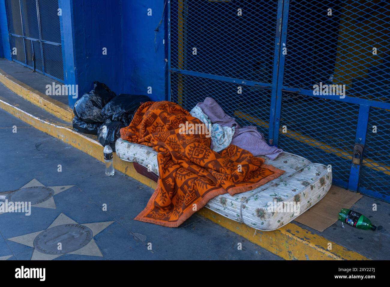 Ein Obdachloser schläft auf einer Matratze auf der Stufe des La Bombonera Stadions in La Boca, Buenos Aires, Argentinien. Stockfoto