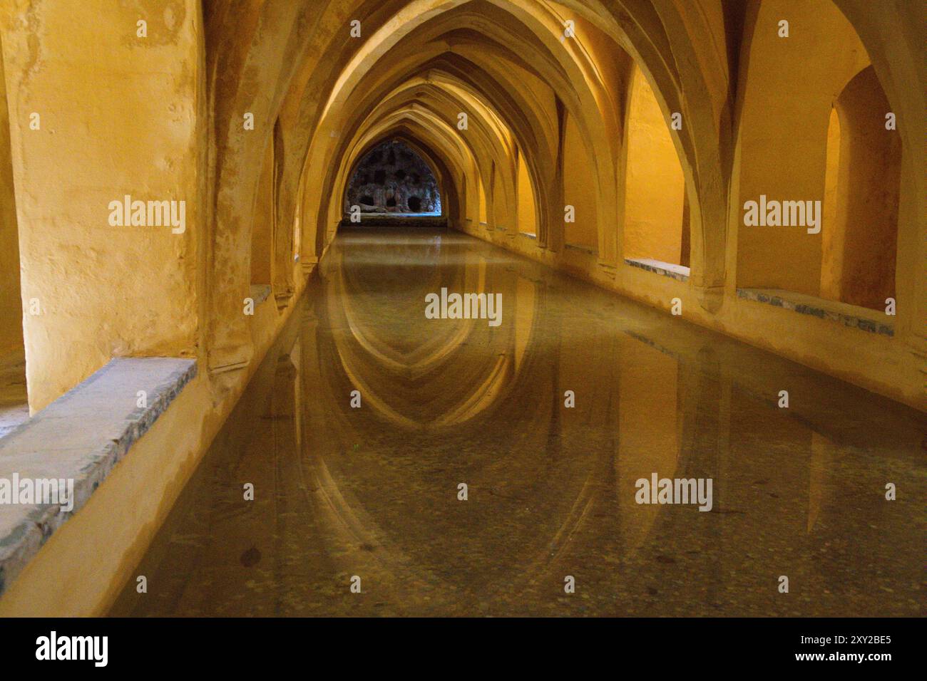 Gelassenheit in Symmetrie: Reflektierende Bögen der Alcazar-Bäder, Sevilla, Andalusien Stockfoto Gelassenheit in Symmetrie: Reflektierende Bögen der Alcazar-Bäder, Sevilla, Andalusien Stockfoto